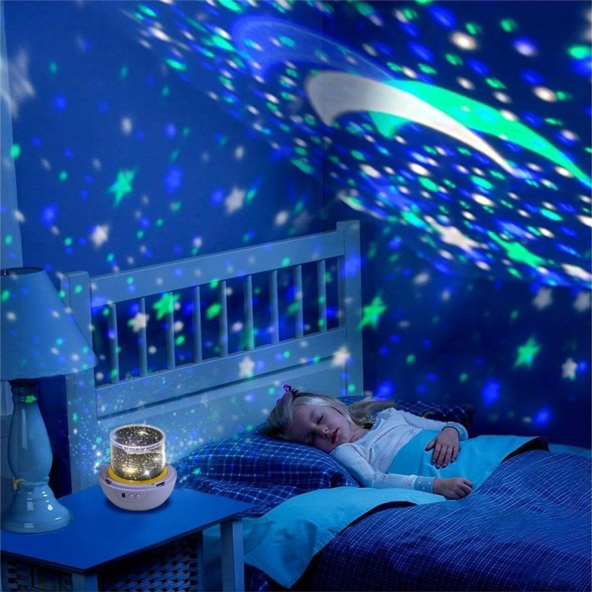 Ein Mädchen schläft unter einem Sternenhimmel, der von einer Lampe projiziert wird.