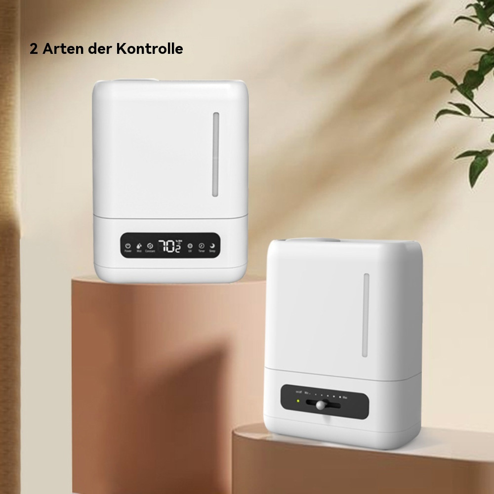 Zwei weiße Luftbefeuchter auf einer braunen Oberfläche. Jeder hat ein digitales Display. Im Hintergrund ist eine Pflanze.