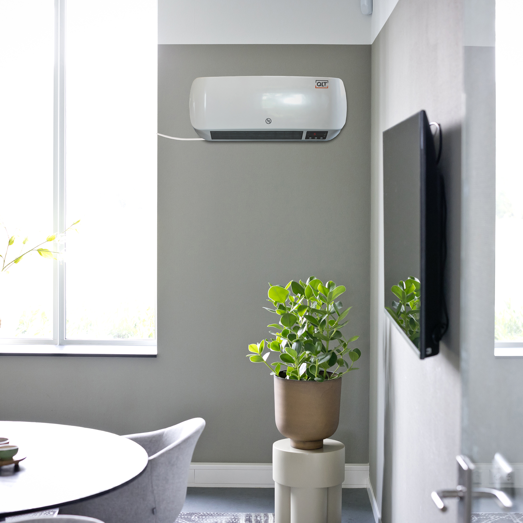 Een witte wandverwarming staat boven een plant op een standaard. Een tv en raam zijn ook aanwezig.