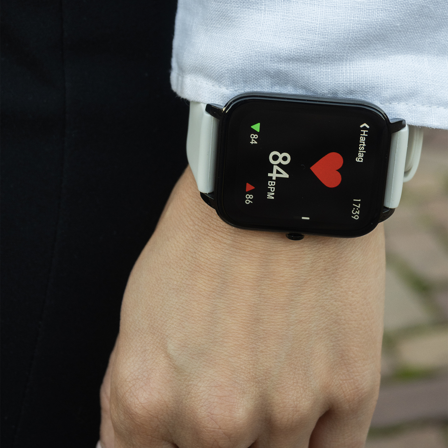 Een smartwatch die een hartslag van 84 bpm weergeeft om de pols van een persoon.