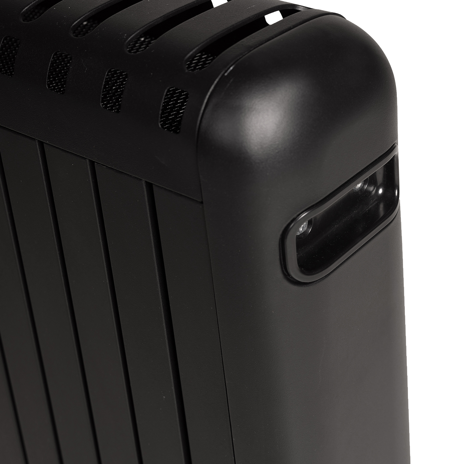A close-up of a black radiator with vertical fins and a rounded corner with a handle.