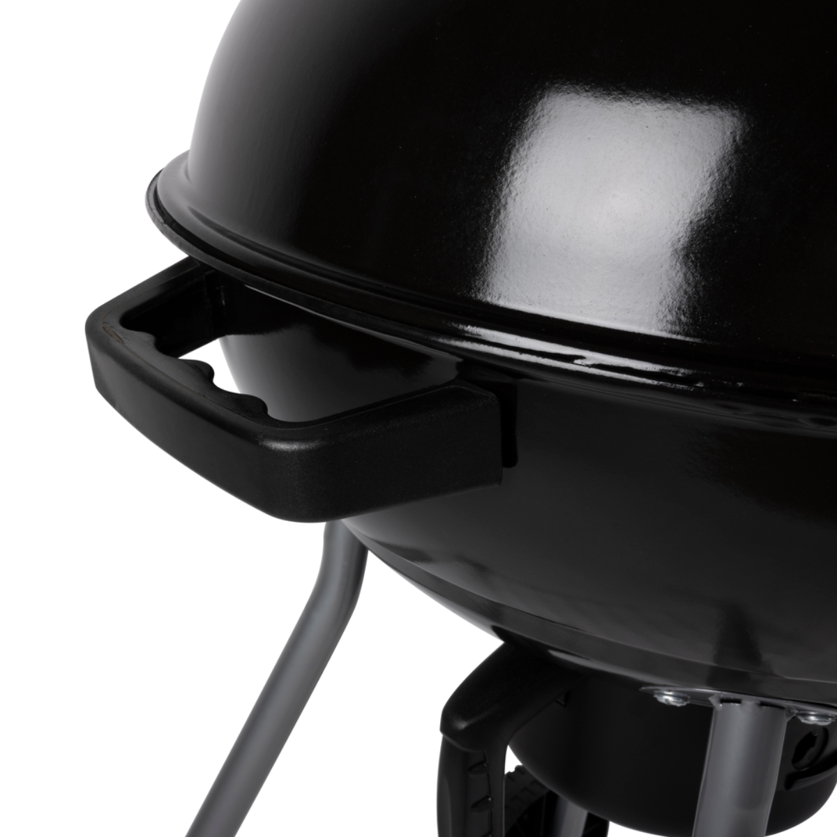 Close-up van een zwarte handgreep van een grilldeksel. De grill zelf is ook zichtbaar.