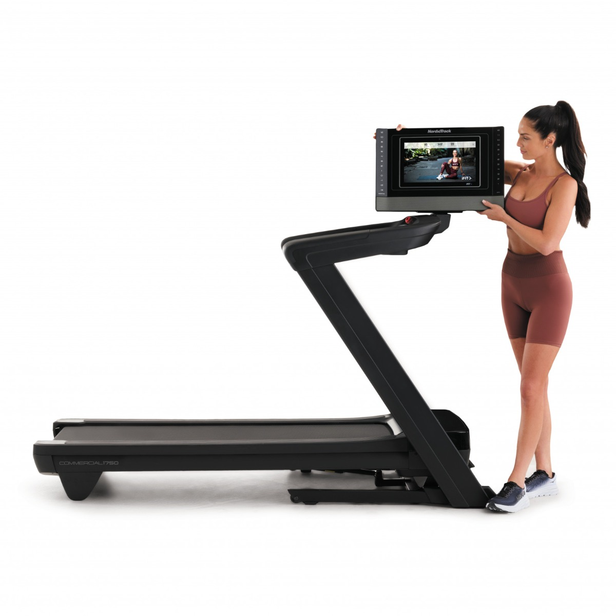 Woman holding the screen of a black treadmill.