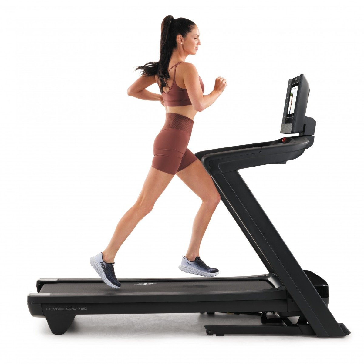Woman running on a black treadmill.