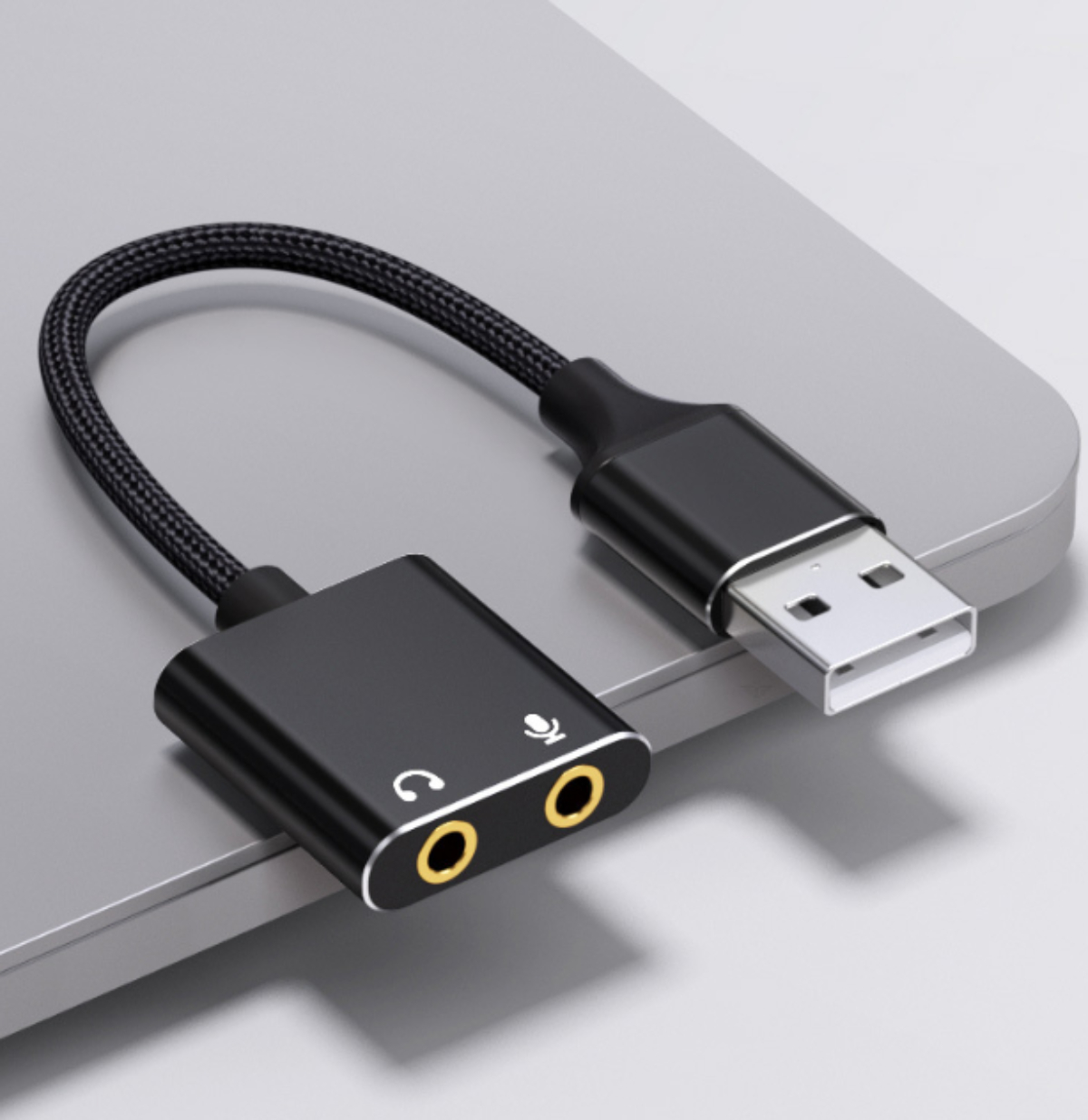 Schwarzer USB-zu-Audio-Adapter. Es hat einen Kopfhörer- und einen Mikrofonanschluss.