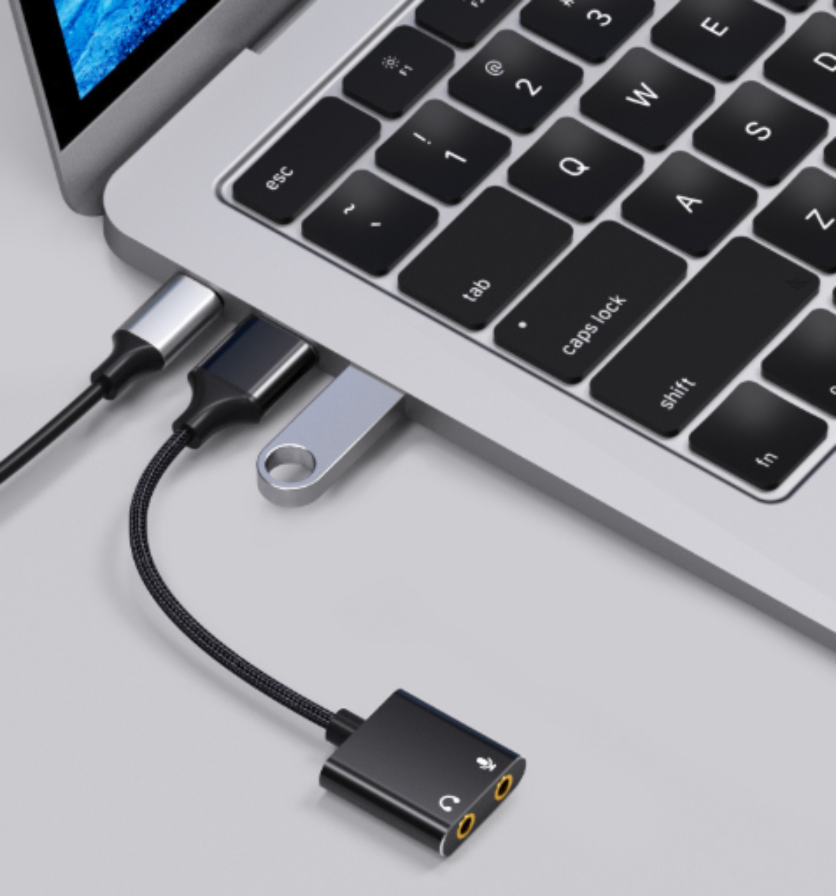 Nahaufnahme von Laptop-Anschlüssen mit angeschlossenen USB- und Audioadapterkabeln.