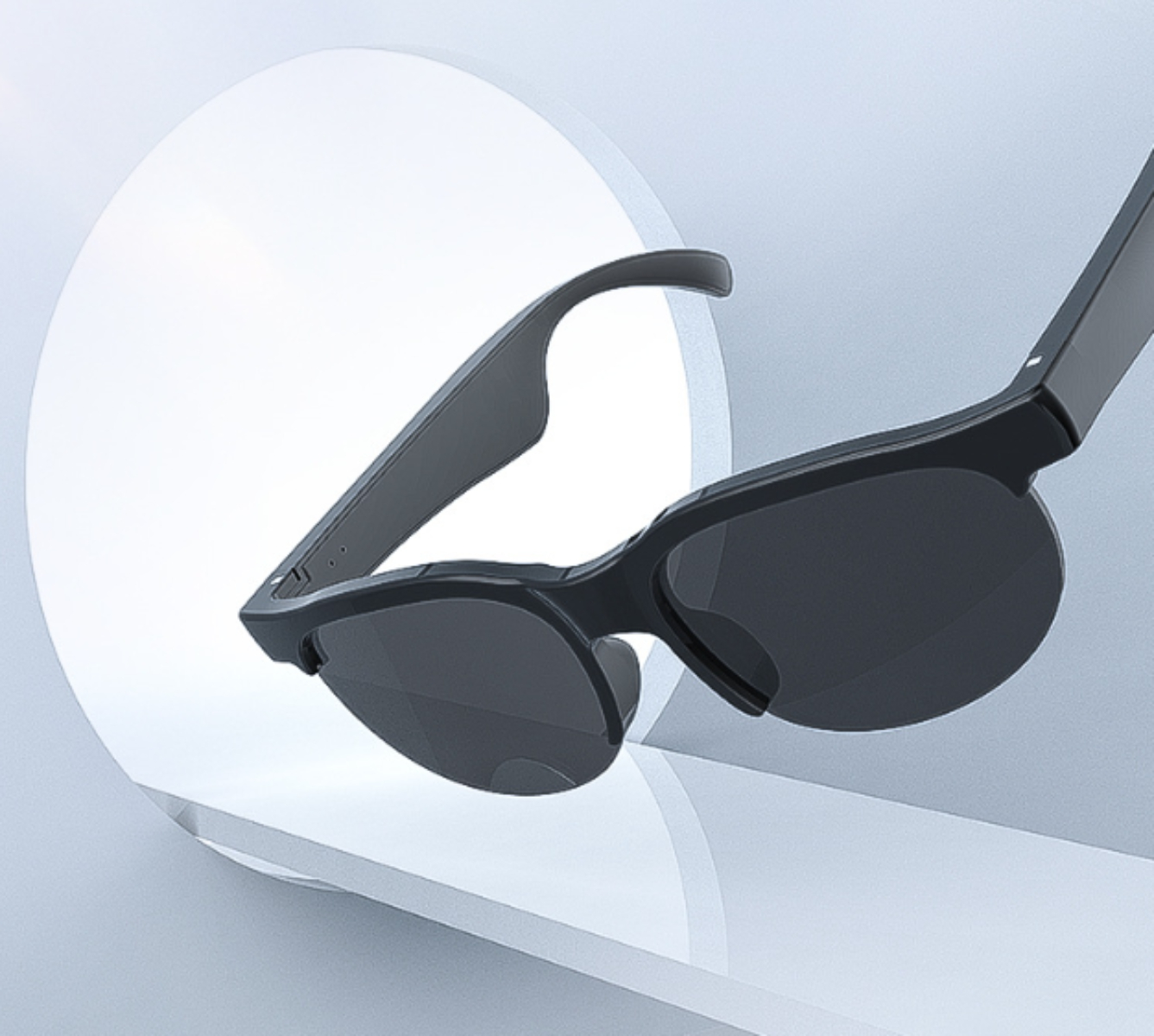 Schwarze Sonnenbrille mit gebogenen Bügeln, auf einem weißen Regal vor weißem Hintergrund.