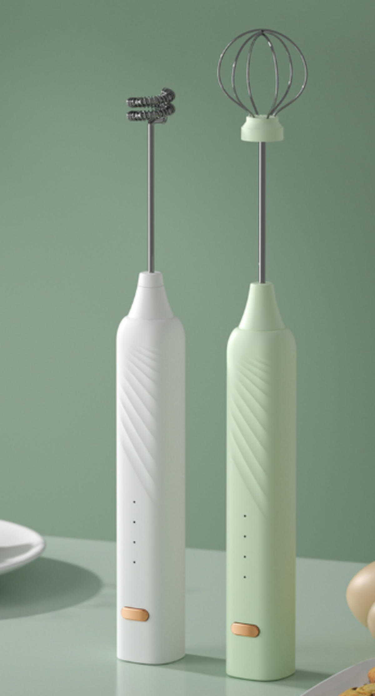 Zwei Handmixer, einer weiß und einer grün, mit verschiedenen Aufsätzen.