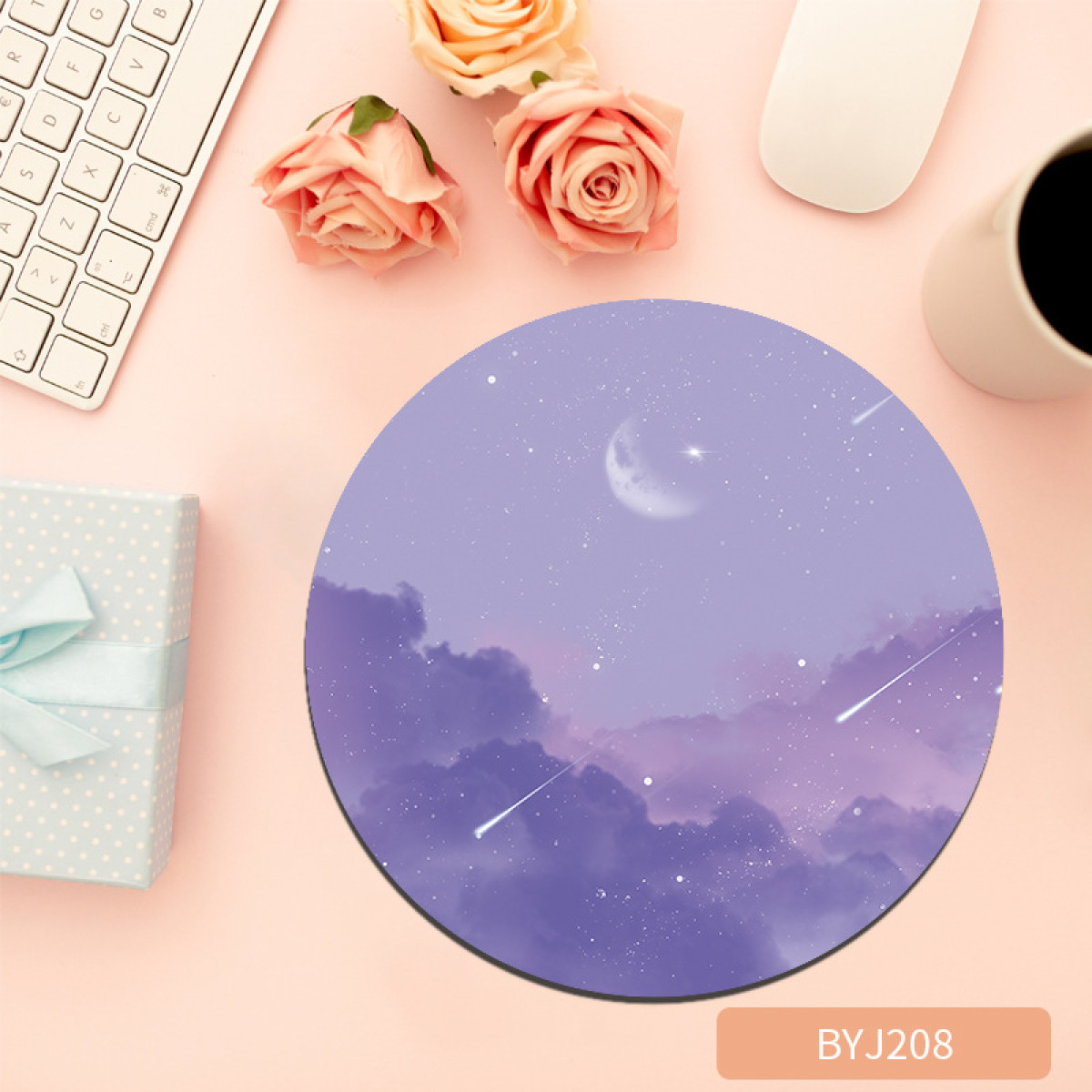 Un tappetino per mouse rotondo viola con un design di cielo notturno. Rose, una tastiera e una tazza di caffè.