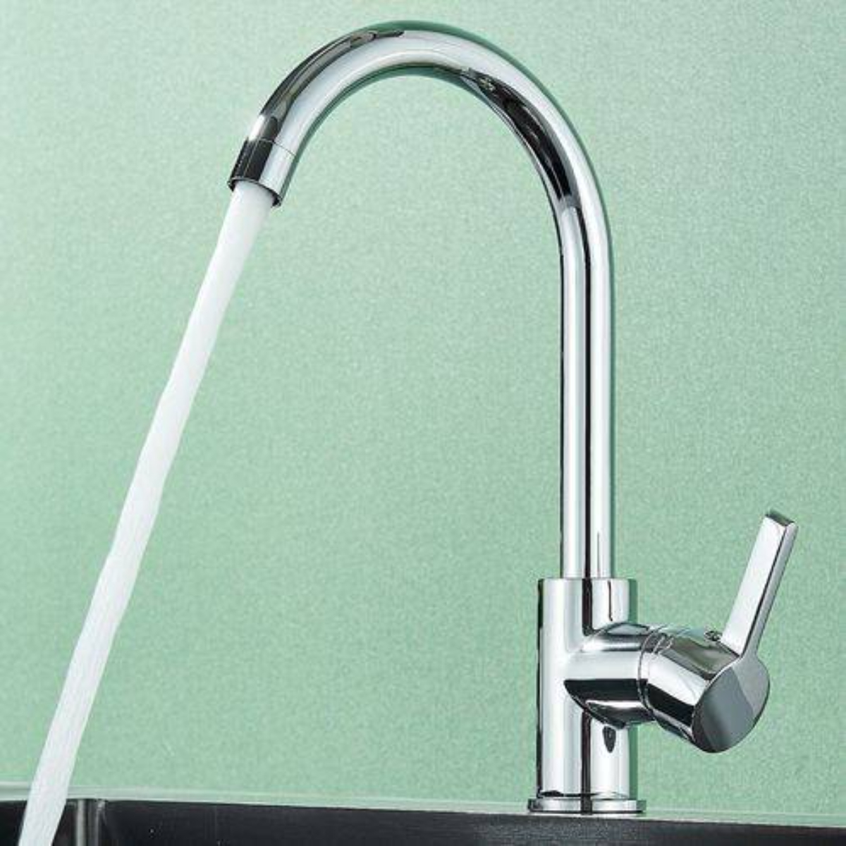Chrom-Wasserhahn mit fließendem Wasser auf hellgrünem Hintergrund.