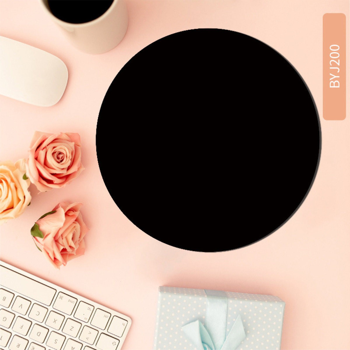 Ein schwarzes Mauspad mit schwarzem Kreis auf pinker Oberfläche. Rosen, Tastatur und Geschenkbox.