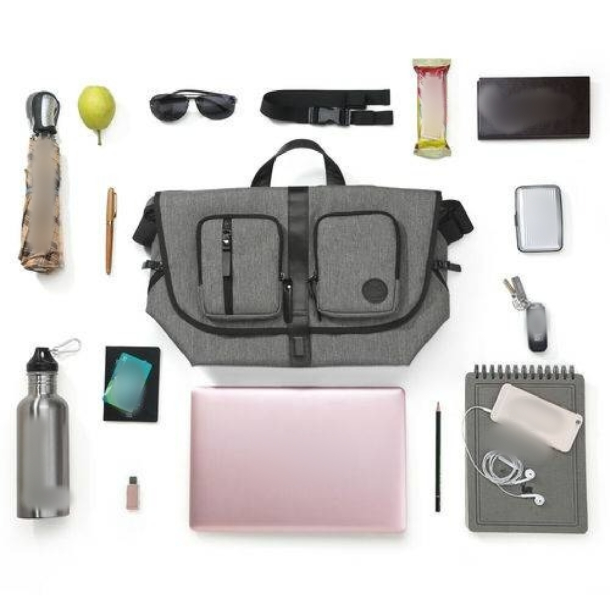 Verschiedene Gegenstände sind auf einer weißen Oberfläche angeordnet, darunter eine Tasche, ein Laptop und Zubehör.