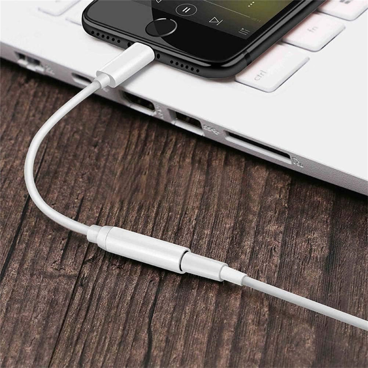 Ein weißes Kabel, das ein Telefon mit einem Laptop verbindet.