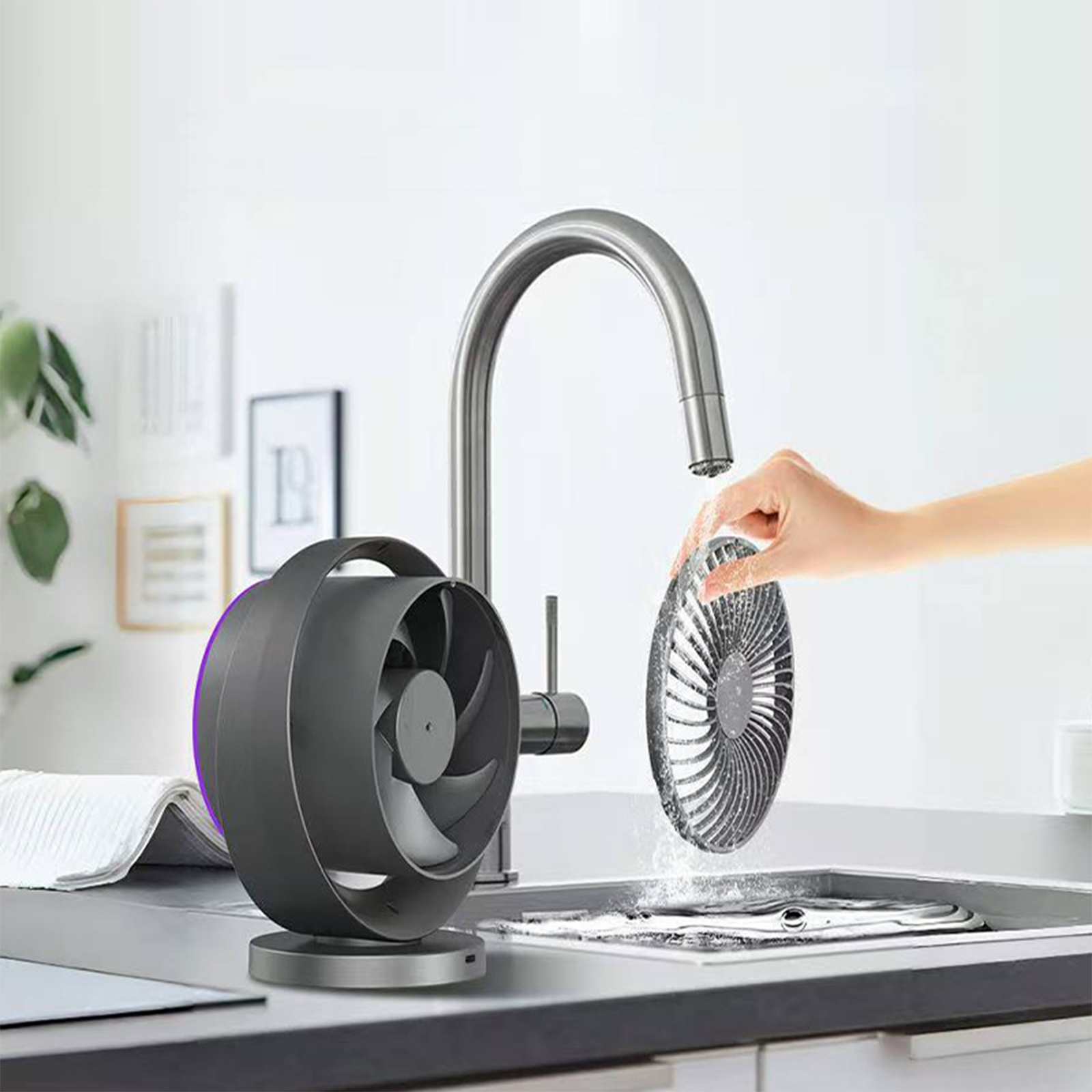 Ein Ventilator, der unter einem Küchenwasserhahn gereinigt wird. Die Lüfterblätter sind entfernt.