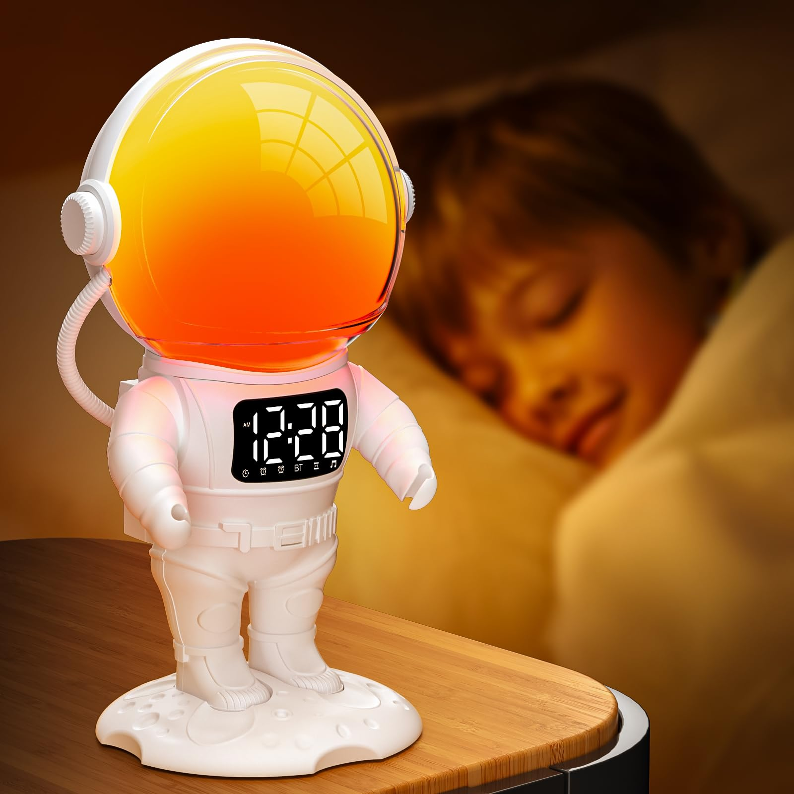 Astronautenförmiger Wecker mit Digitalanzeige, orangefarbenem Visier, auf Holzoberfläche, im Hintergrund schlafende Person.