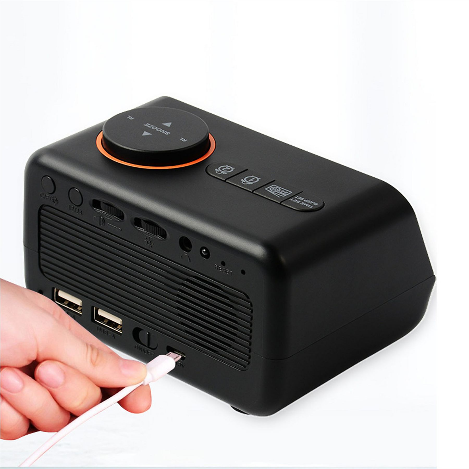 Schwarzer Radio-Wecker mit USB-Anschlüssen. Eine Hand steckt ein weißes USB-Kabel in das Gerät.