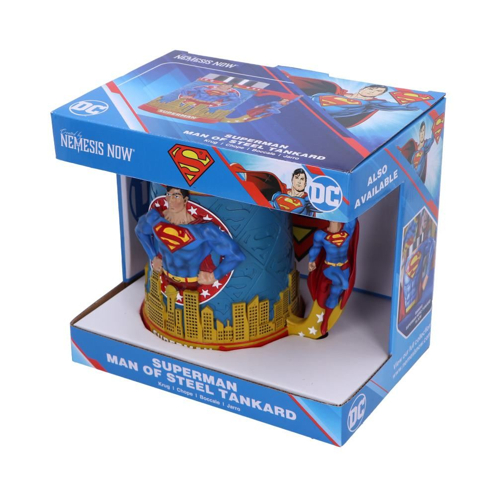 A Superman mug in its box. The mug is blue with Superman images and a yellow handle.