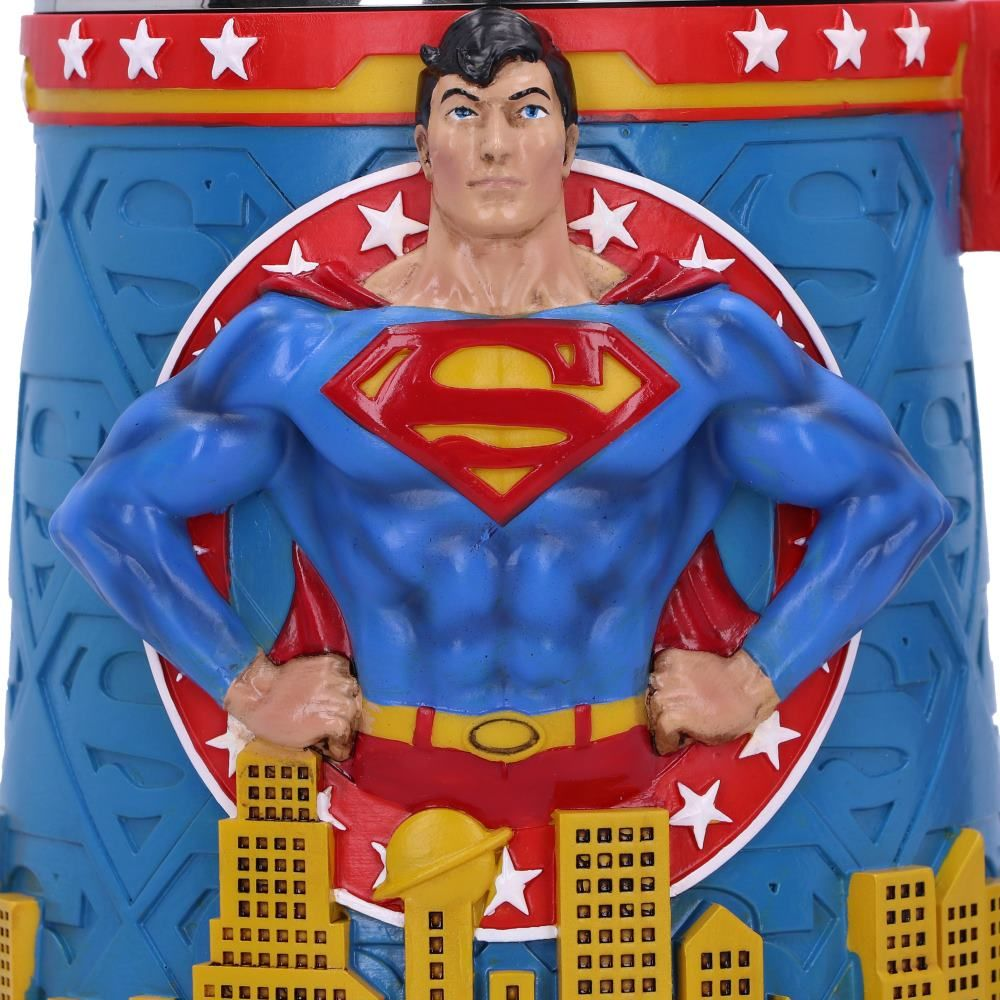 Superman figure. The figure is blue and red. It is in front of a city.