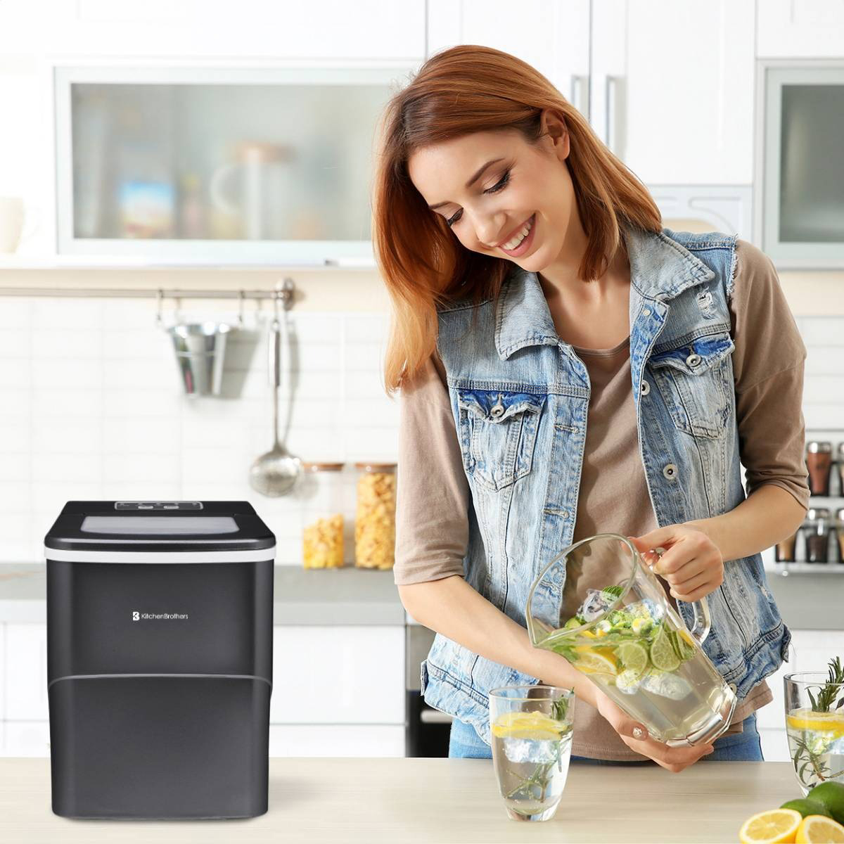 Woman smiling, pouring water from a pitcher into a glass with ice and lemon. Ice machine is in the background.