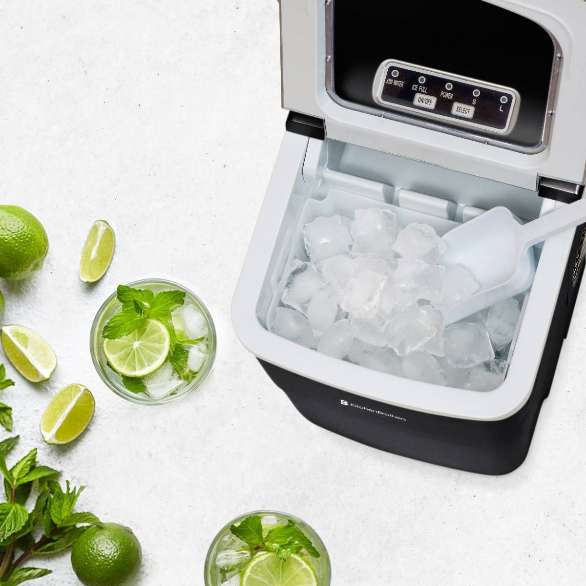 An ice maker with ice and a scoop. Two glasses of mojitos with limes and mint.