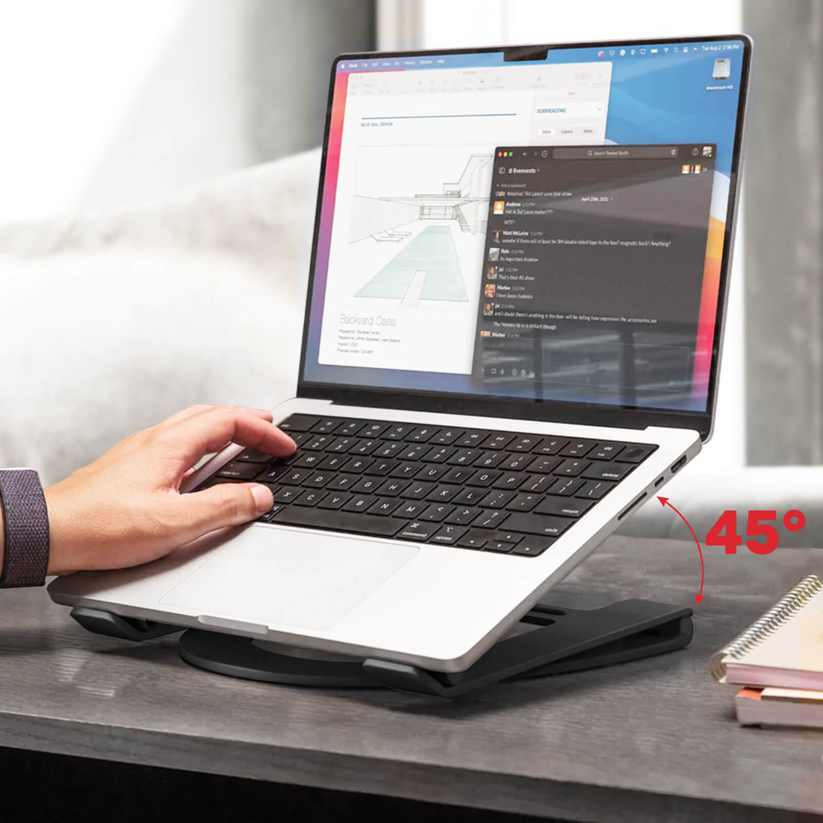 Man using laptop on a stand, with a 45-degree angle, on a desk.