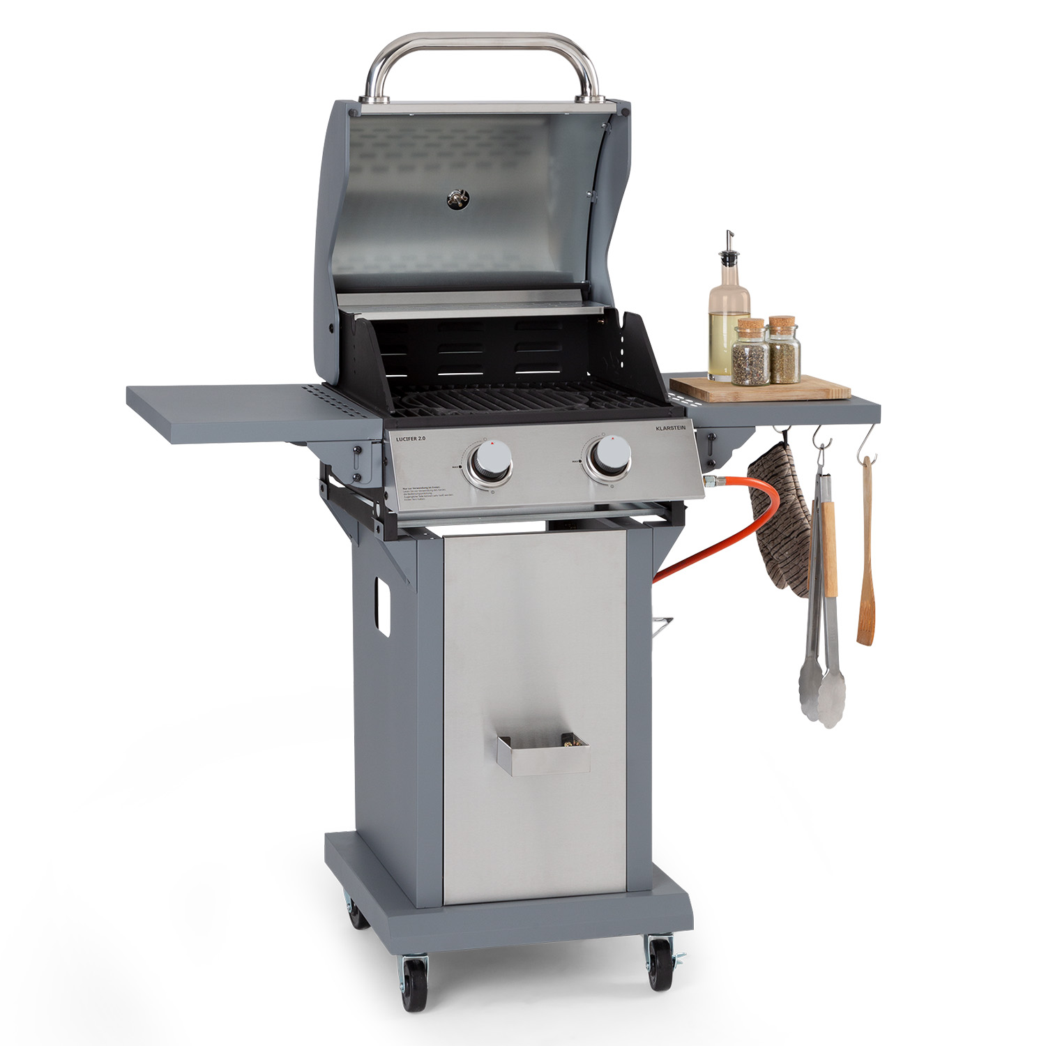 Grauer Gasgrill mit geöffnetem Deckel. Beistelltisch mit Ölflaschen, Zangen.