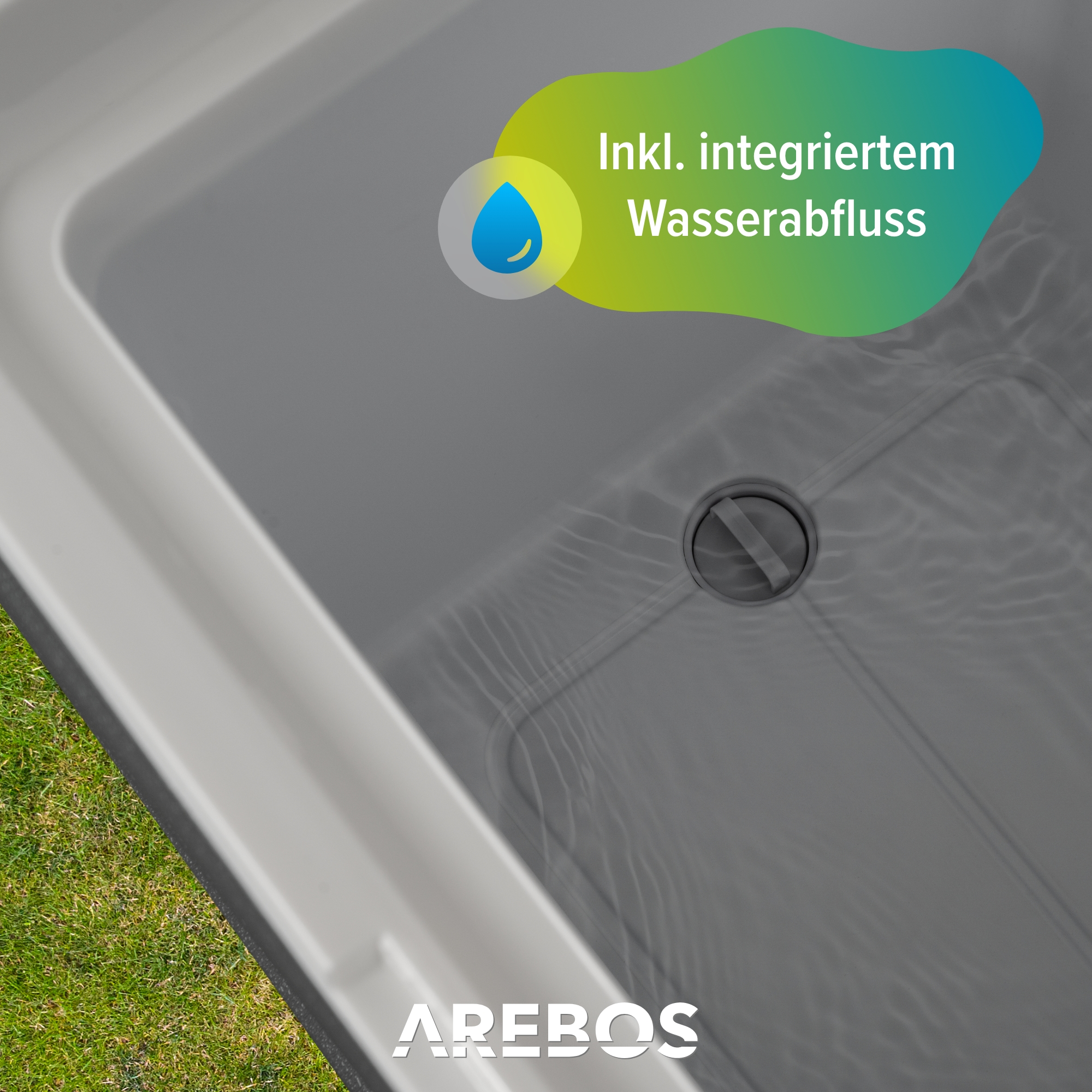 Graues Waschbecken mit Abflussloch. Der Text besagt, dass es einen integrierten Wasserablauf hat.