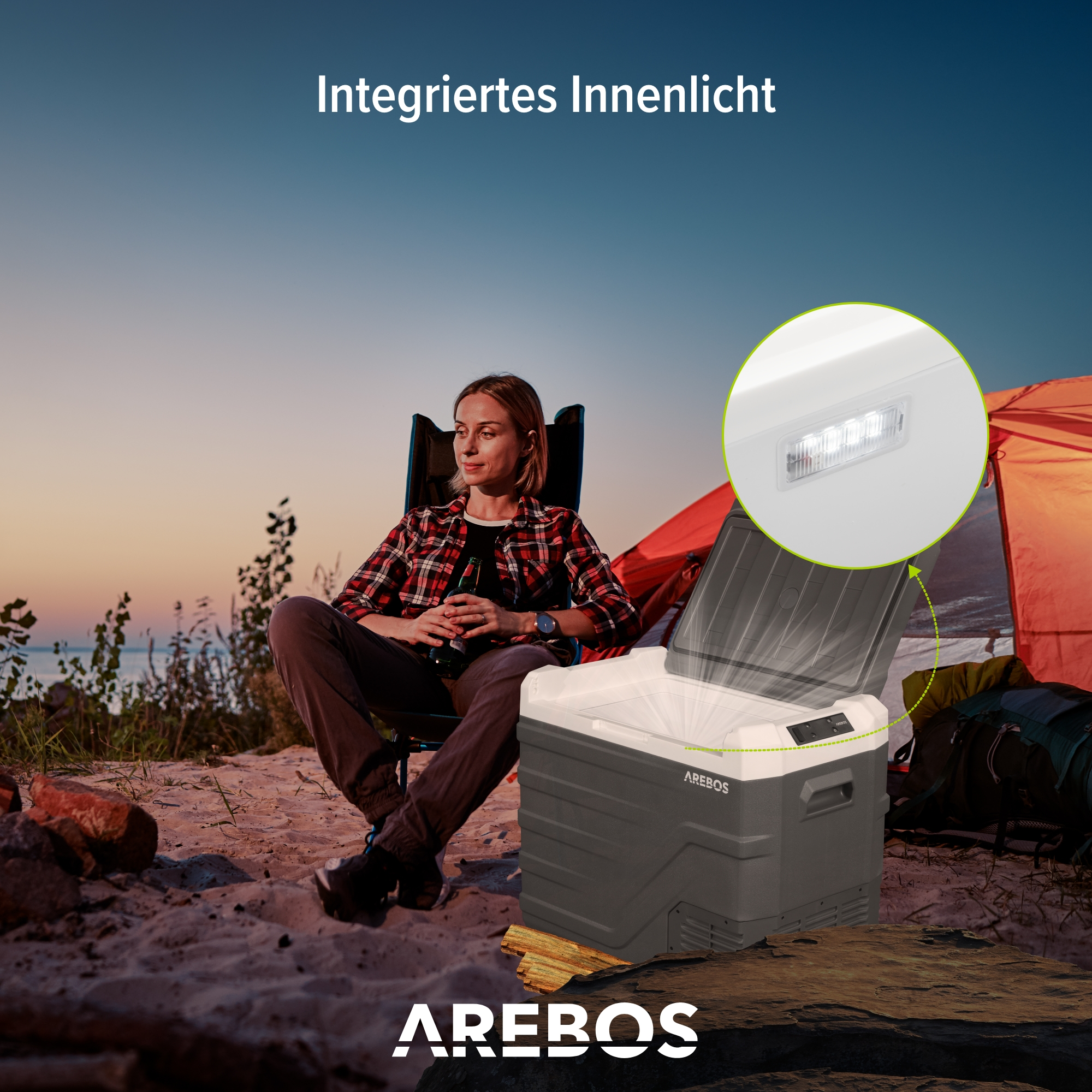 Eine Frau sitzt in der Nähe einer Kühlbox auf einem Campingplatz. Die Kühlbox ist geöffnet, Innenlicht an.