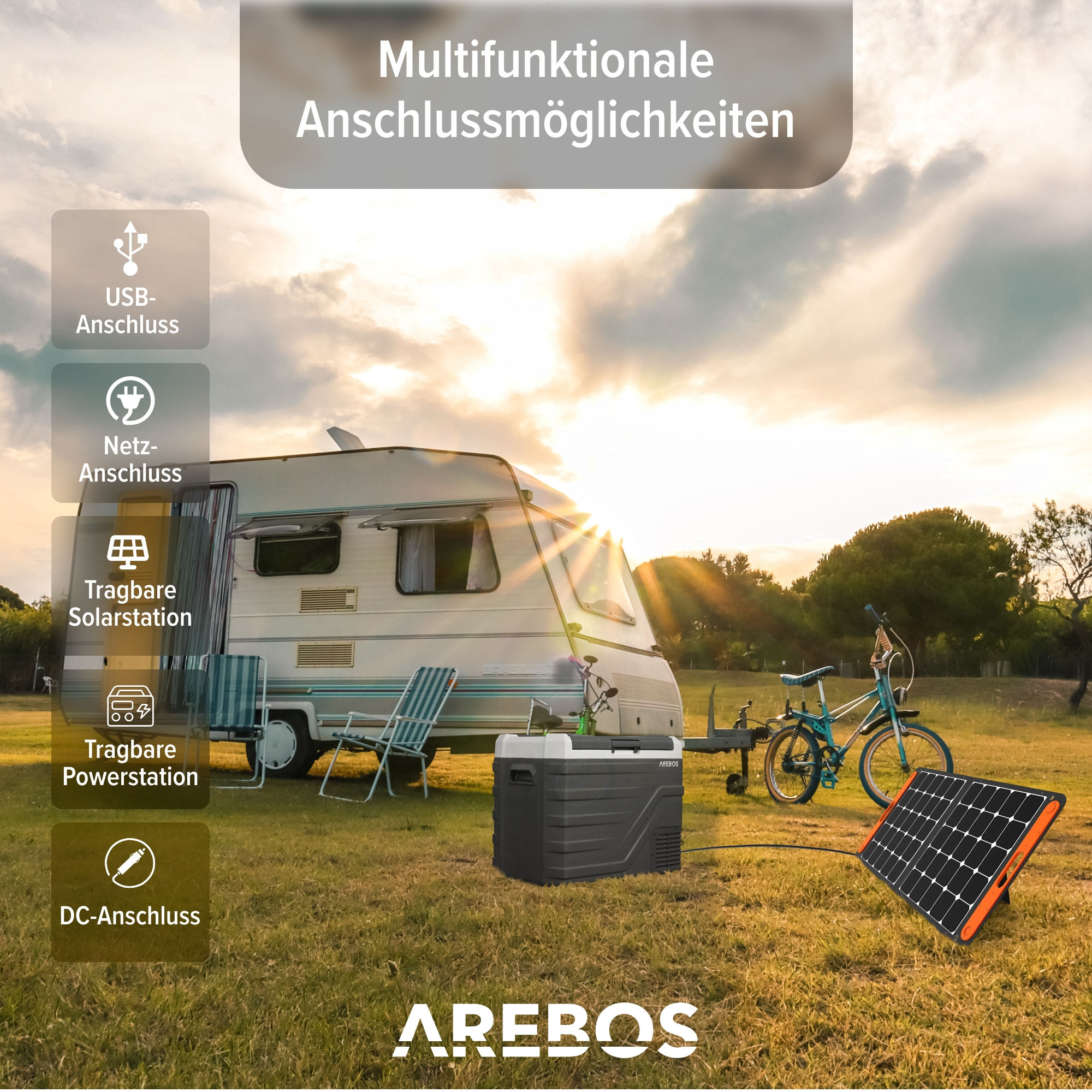 Eine mobile Stromstation mit Wohnwagen, Solarpanel und Fahrrad in einer sonnigen Umgebung im Freien.