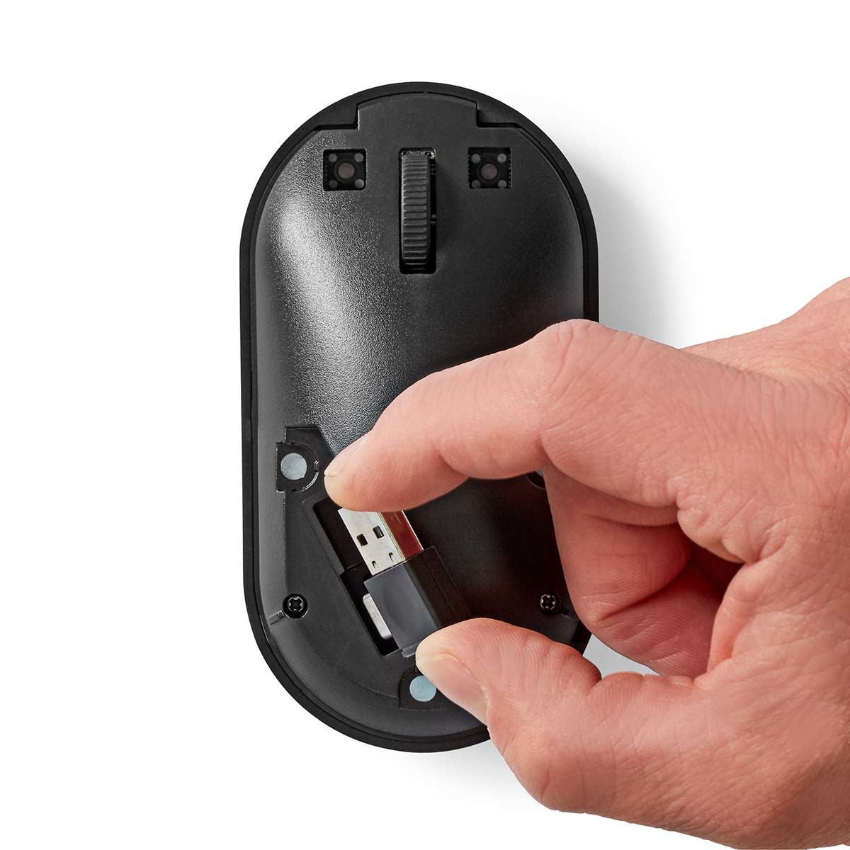 Eine Hand, die einen USB-Empfänger in die Unterseite einer schwarzen Computermaus steckt.