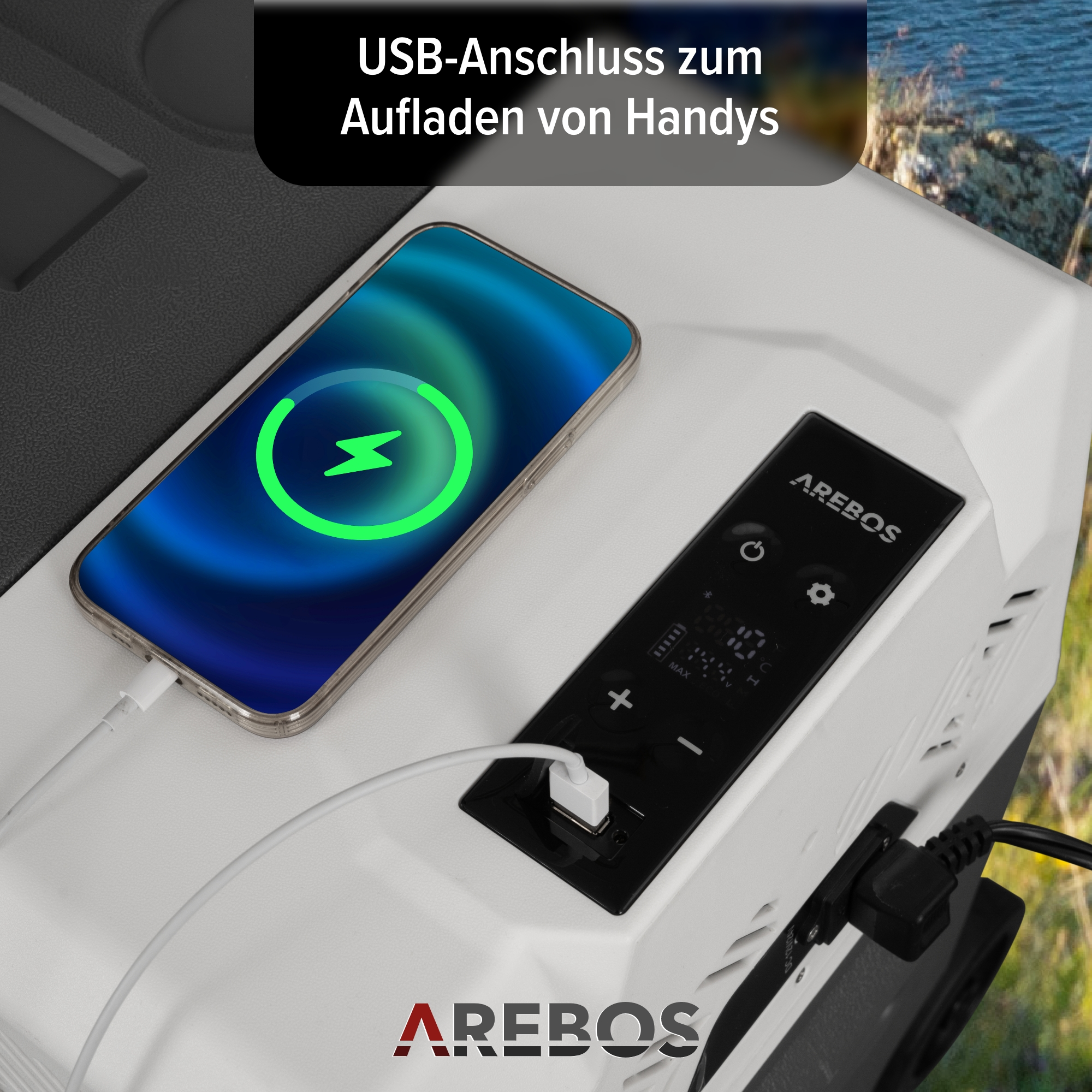 Telefon wird an einem Kühler geladen. Auf dem Bildschirm wird das Laden angezeigt. Text: USB-Anschluss zum Aufladen von Handys.