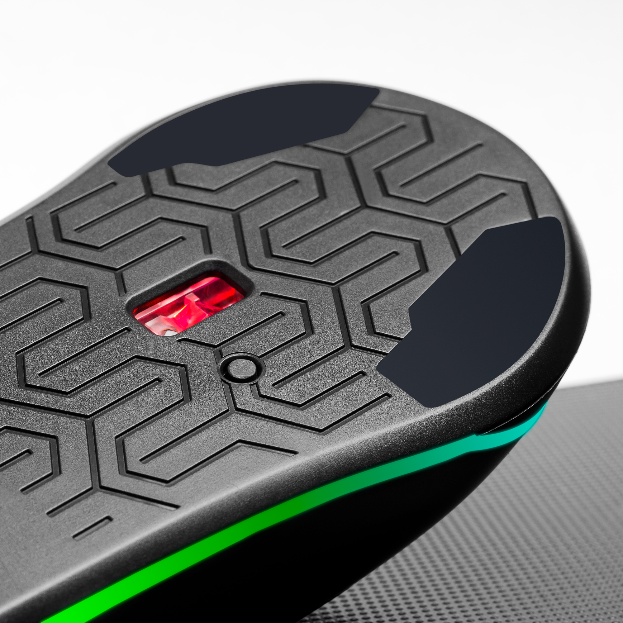 Vista inferiore di un mouse nero con luce rossa e motivo geometrico. Sfondo bianco e nero.