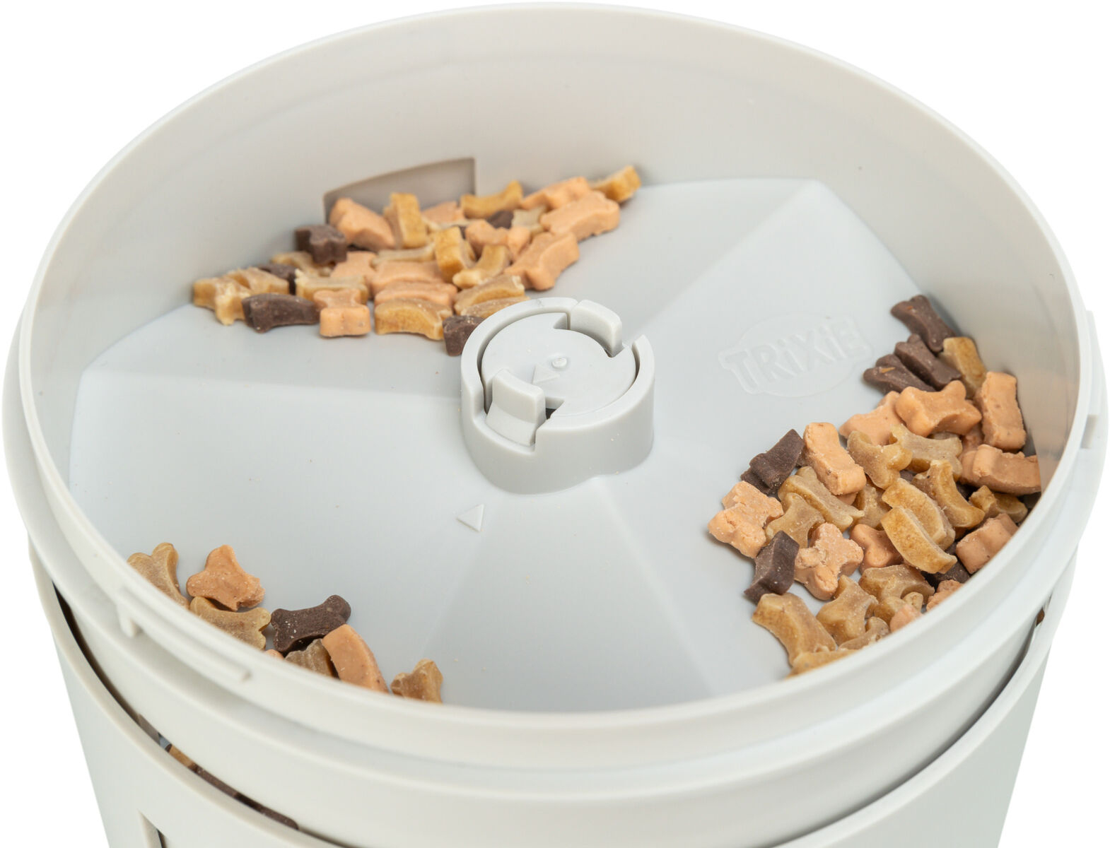 Biały dozownik karmy dla zwierząt z kawałkami suchej karmy w środku.