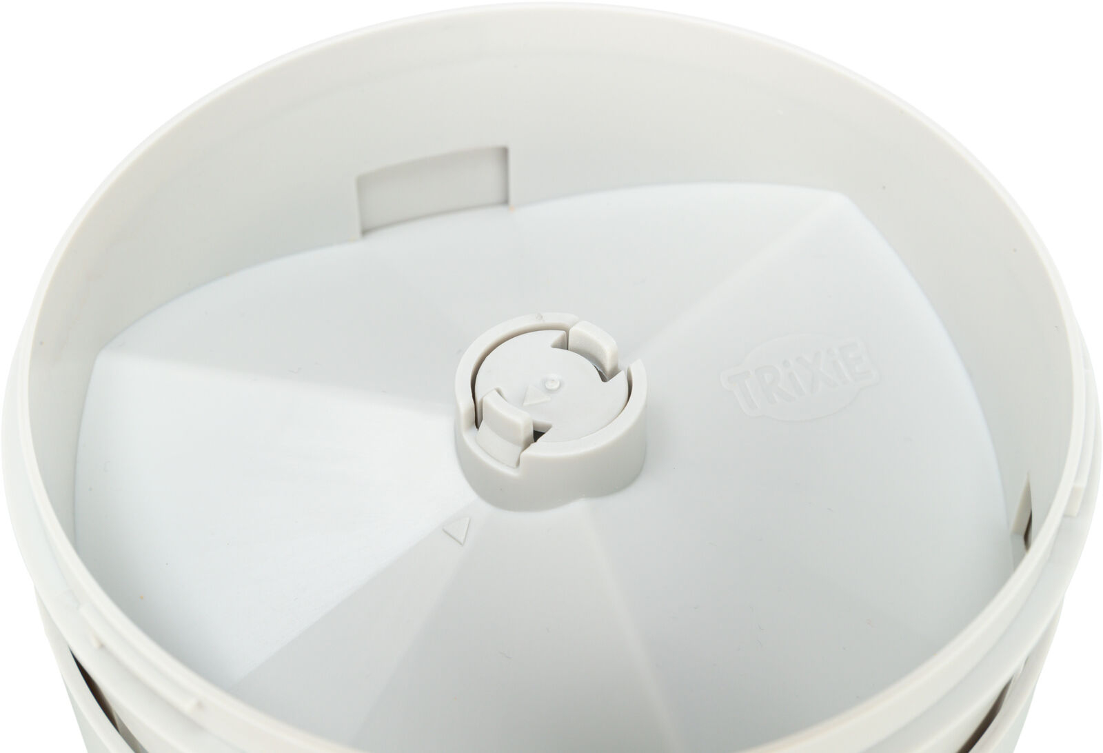 Zbliżenie białego karmnika dla zwierząt, okrągły design z centralnym pokrętłem.