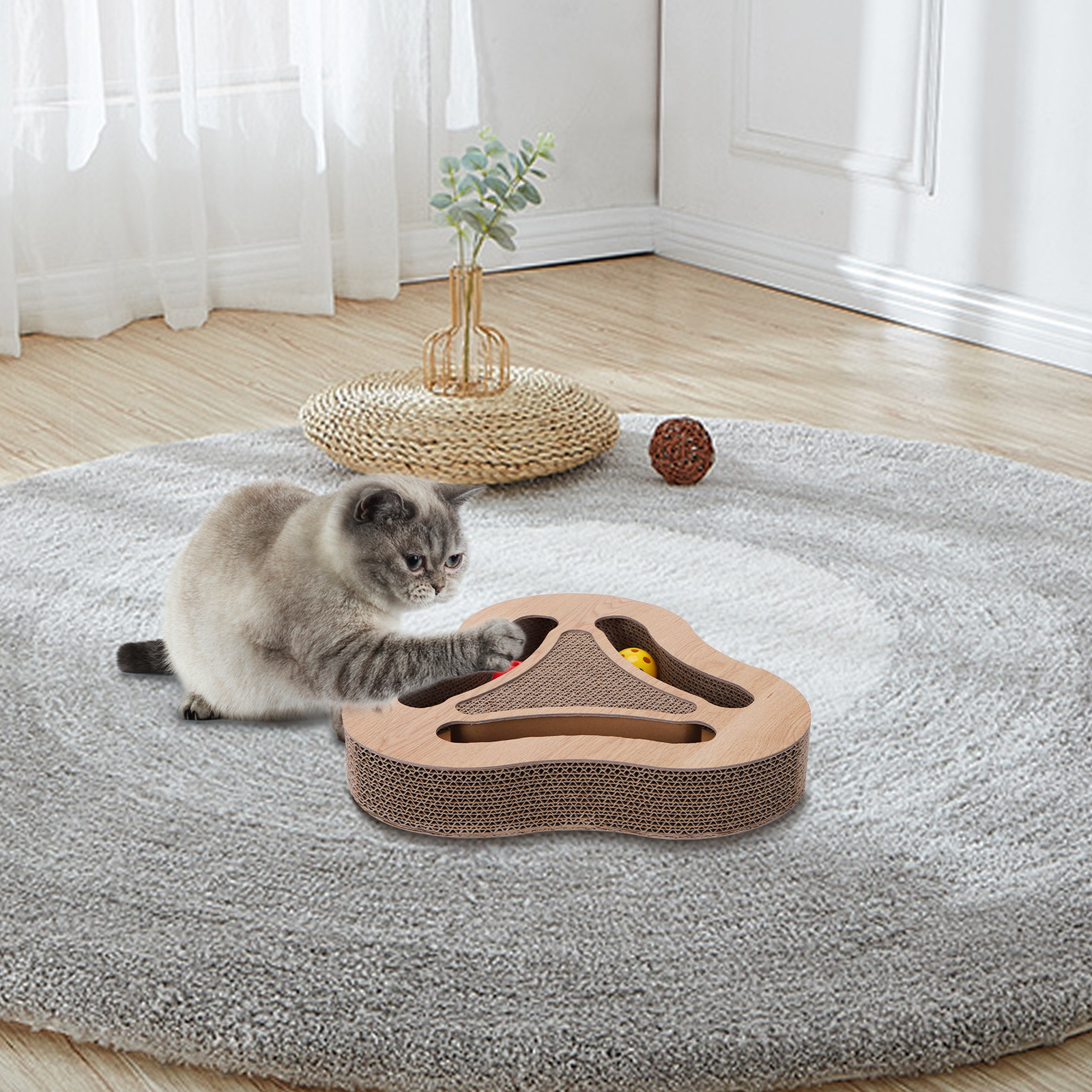 Gato jugando con un juguete. El gato está en una alfombra, con un juguete delante.