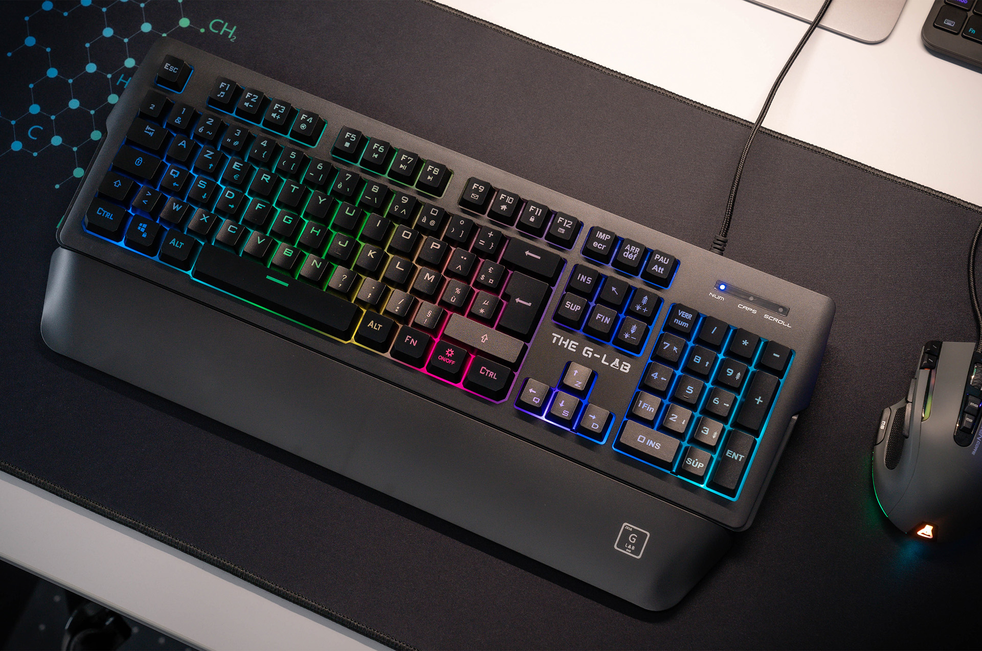 Czarna klawiatura z kolorowymi klawiszami i mysz na czarnej macie.