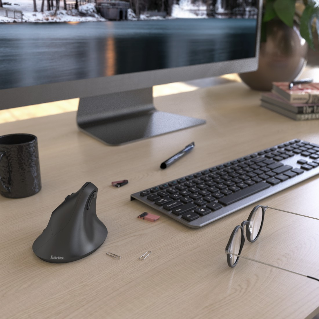 Scena biurowa z monitorem komputera, klawiaturą, myszką, okularami i innymi materiałami biurowymi.