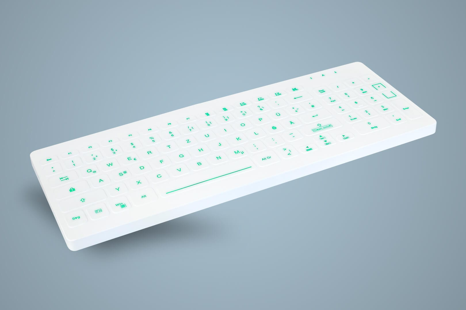 Weiße Tastatur mit grünen Buchstaben auf hellblauem Hintergrund. Schräge Perspektive.
