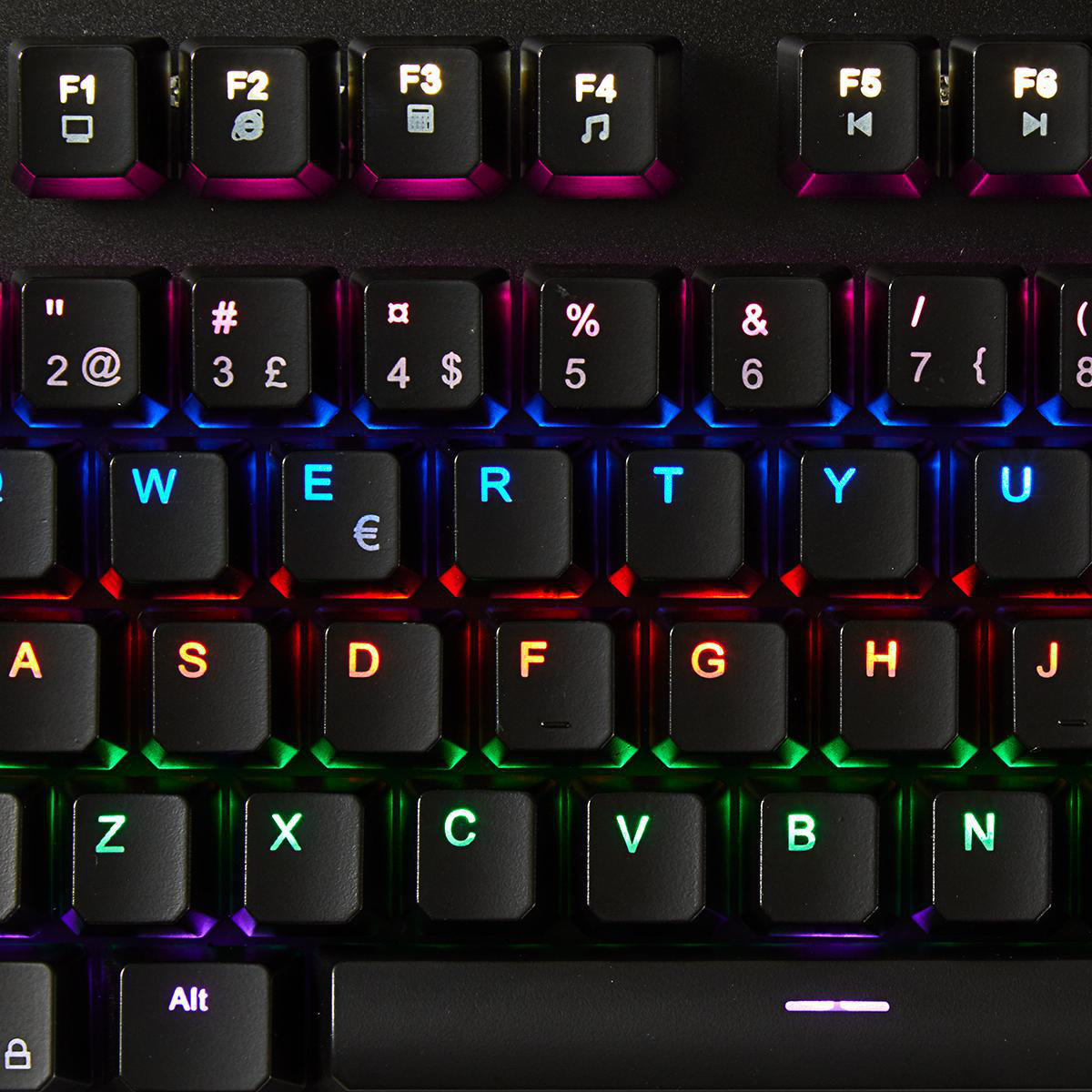 Nahaufnahme von hinterleuchteten Tastaturtasten. Buchstabentasten sind schwarz mit unterschiedlicher Farbbeleuchtung. Bunt.