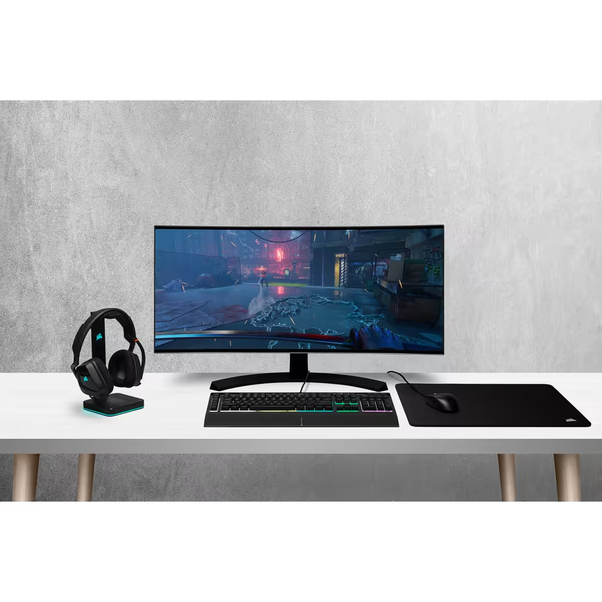 Konfiguracja do gier z monitorem, klawiaturą, myszą, podkładką i zestawem słuchawkowym na białym biurku.