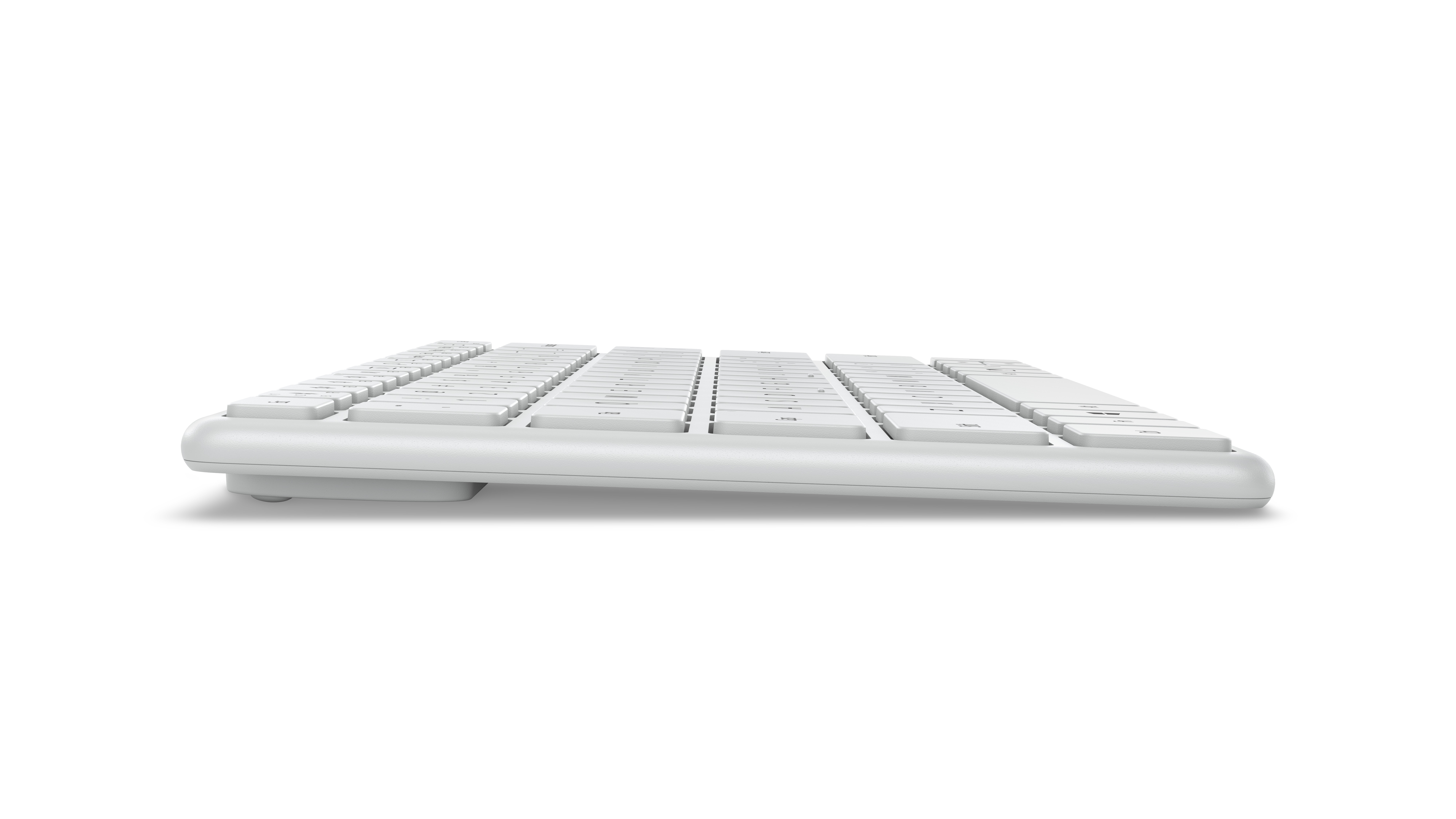 Un teclado blanco desde una vista lateral, con las teclas visibles, sobre un fondo blanco.