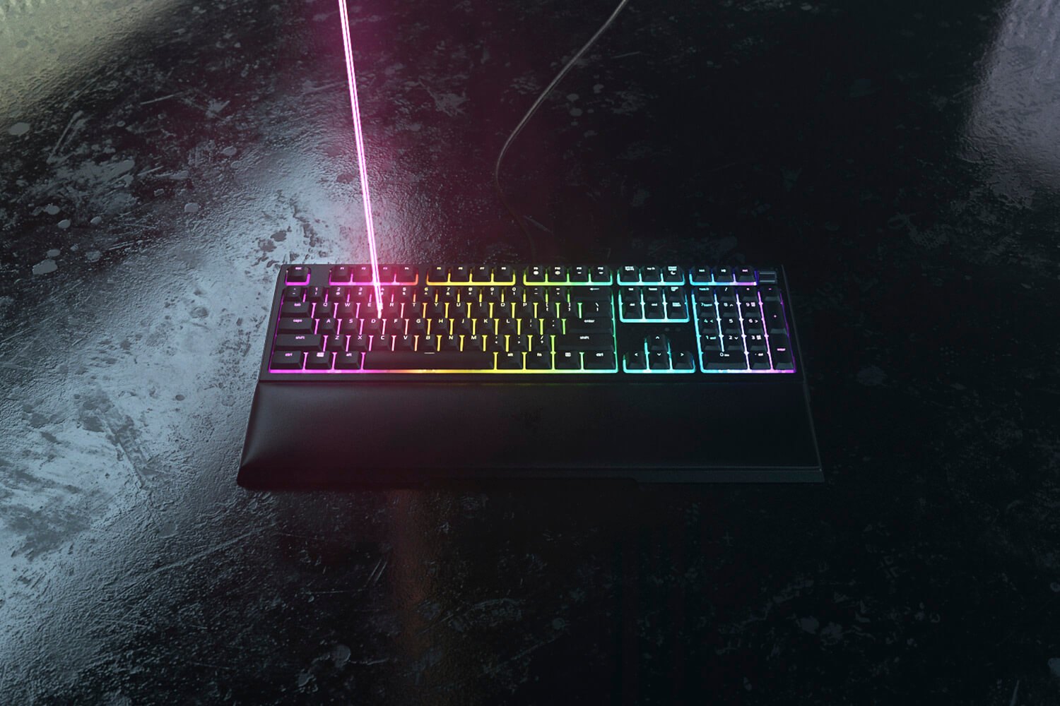 Schwarze Tastatur mit bunten Tasten, einem Lichtstrahl und dunklem Hintergrund.