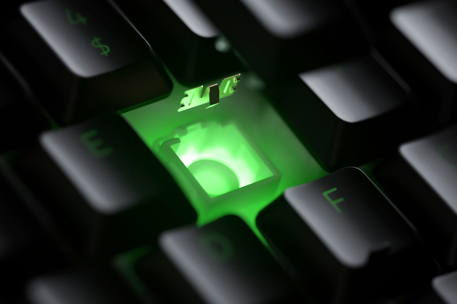 Nahaufnahme einer Tastaturtaste mit grünem Licht, Mechanismus sichtbar.