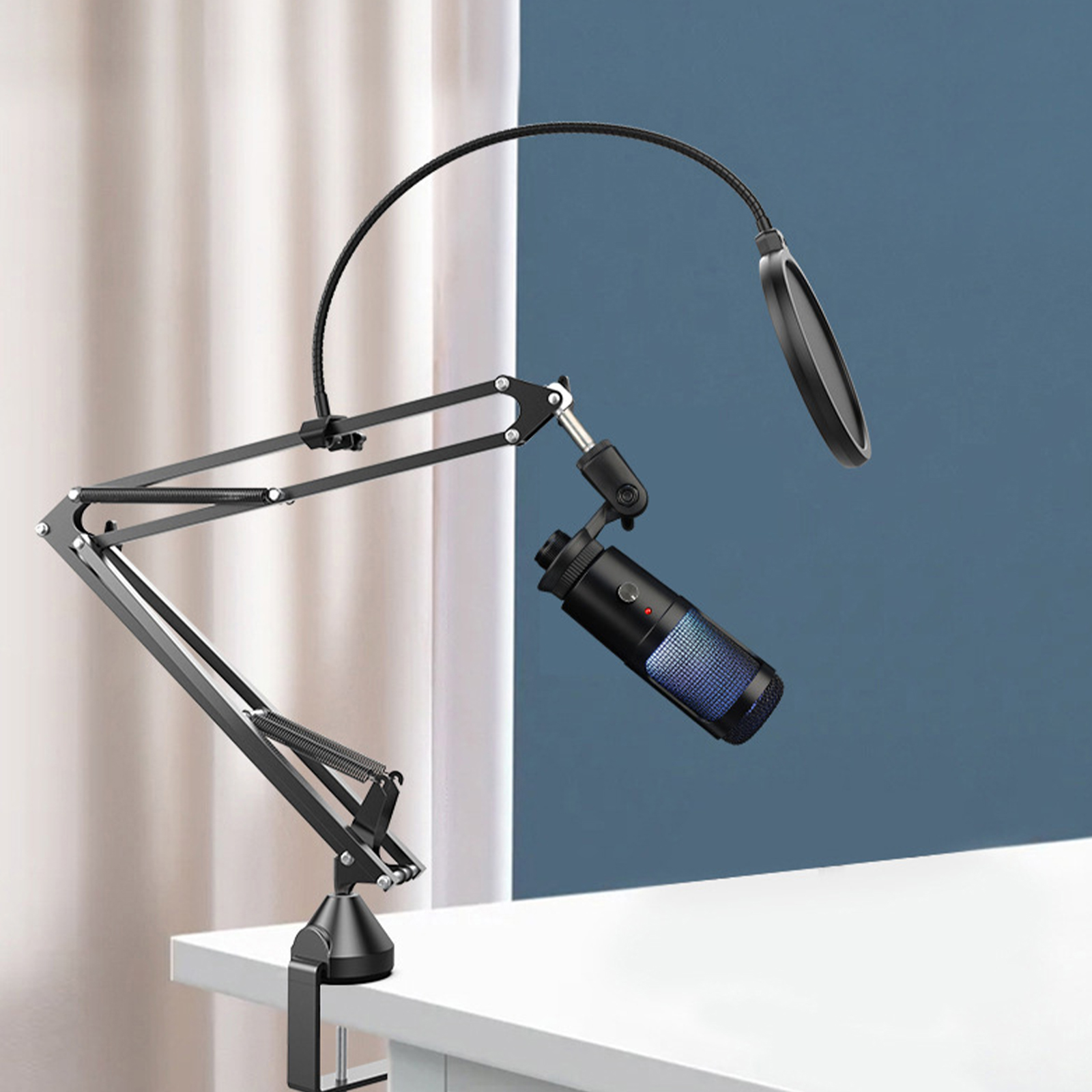 Schwarzes Mikrofon mit Pop-Filter, montiert auf einem schwarzen, verstellbaren Arm, auf einem weißen Schreibtisch.