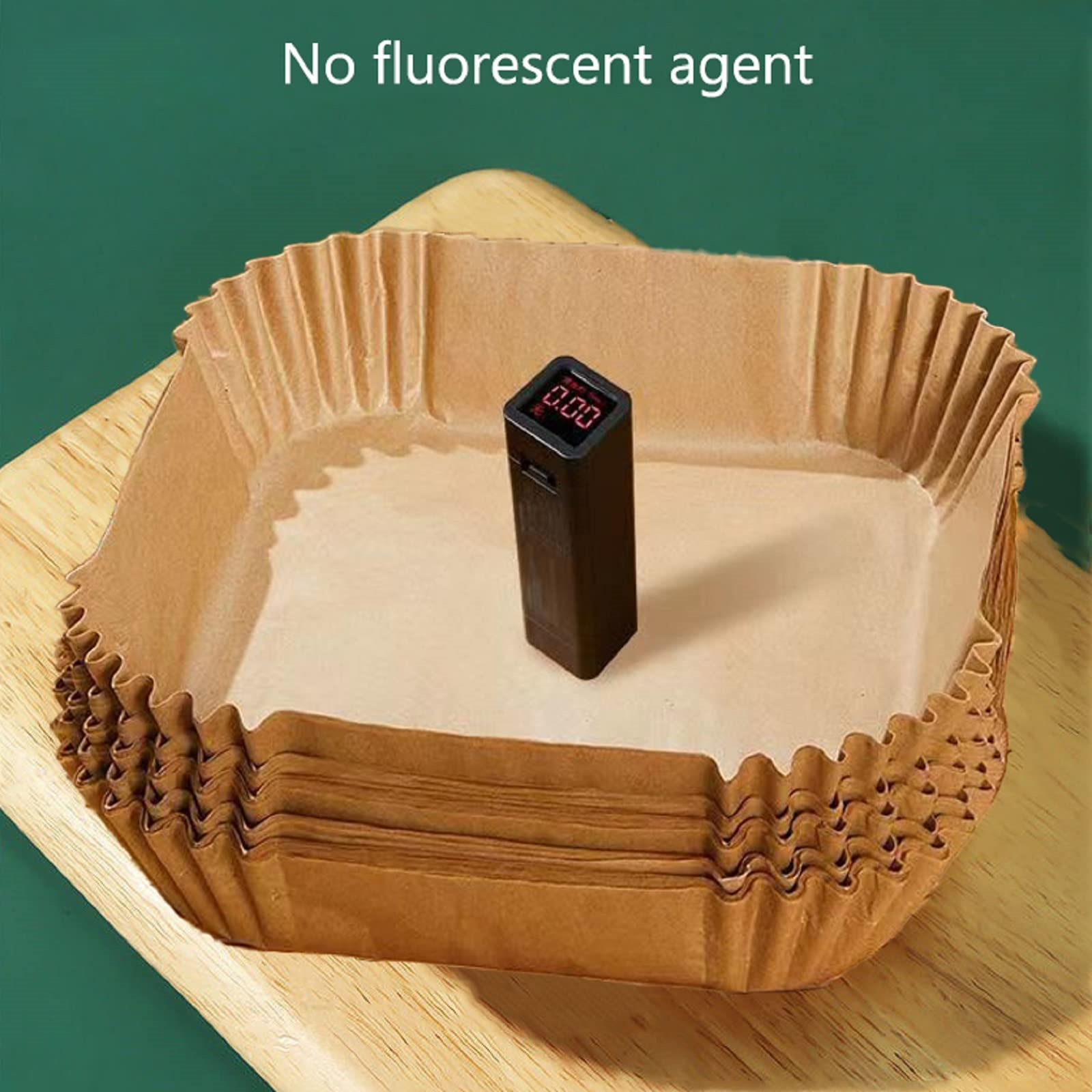 Braune Papier-Cupcake-Formen mit einem schwarzen Digitalthermometer auf Holz.