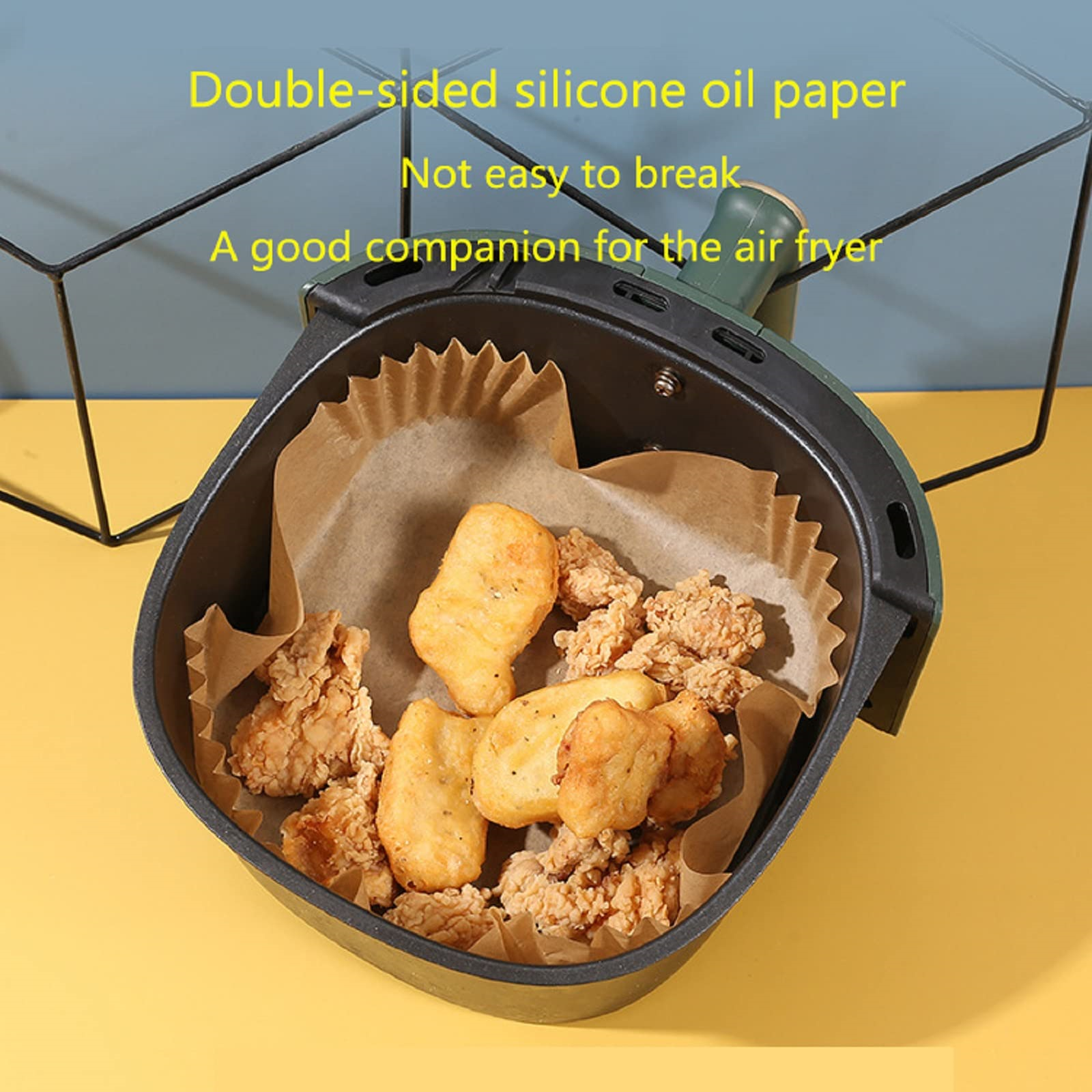 Heißluftfritteuse mit Essen, Text über Silikonölpapier.