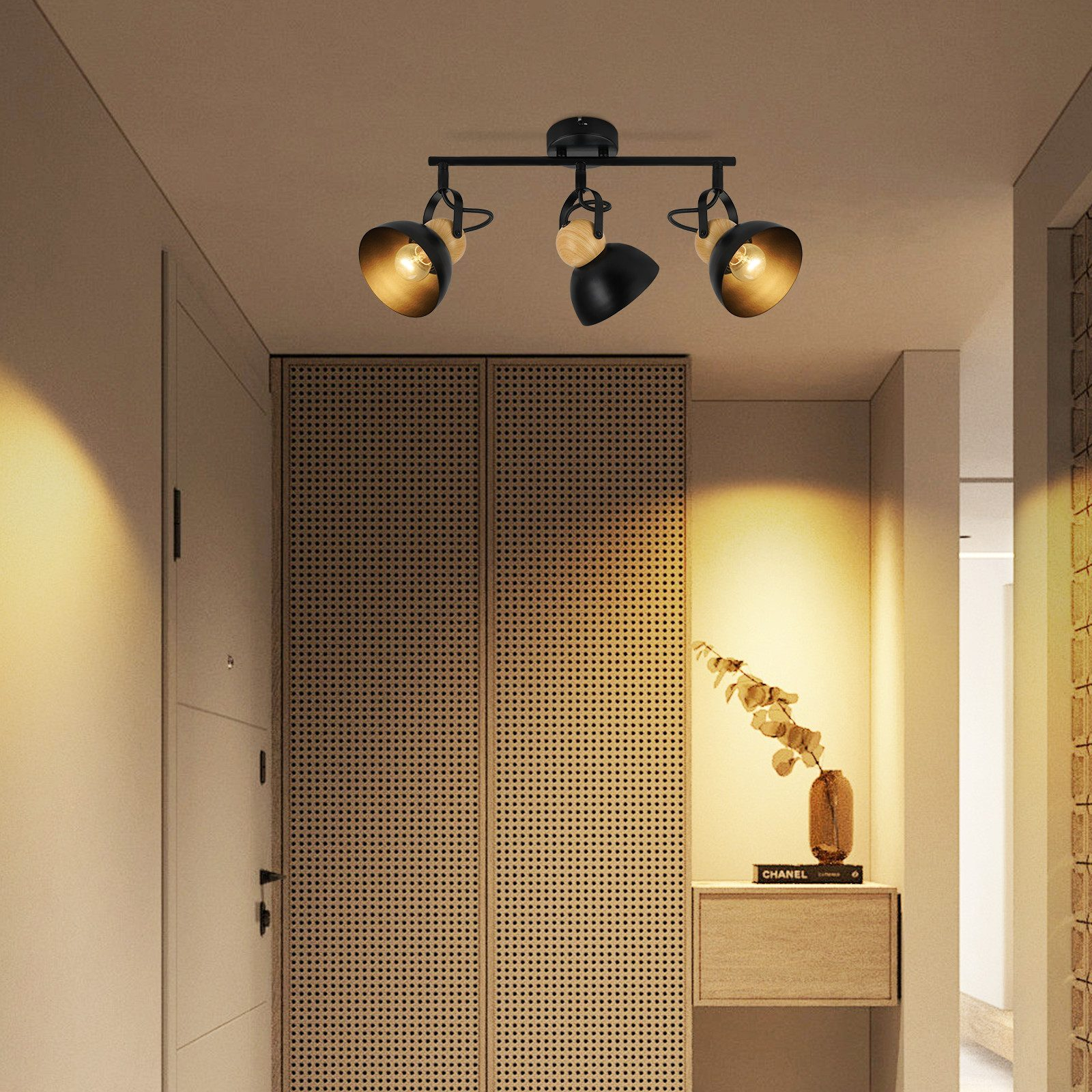 Trzypunktowa oprawa oświetleniowa szynowa, czarna, z włączonymi światłami, w strefie wejścia z drewnianym wystrojem.