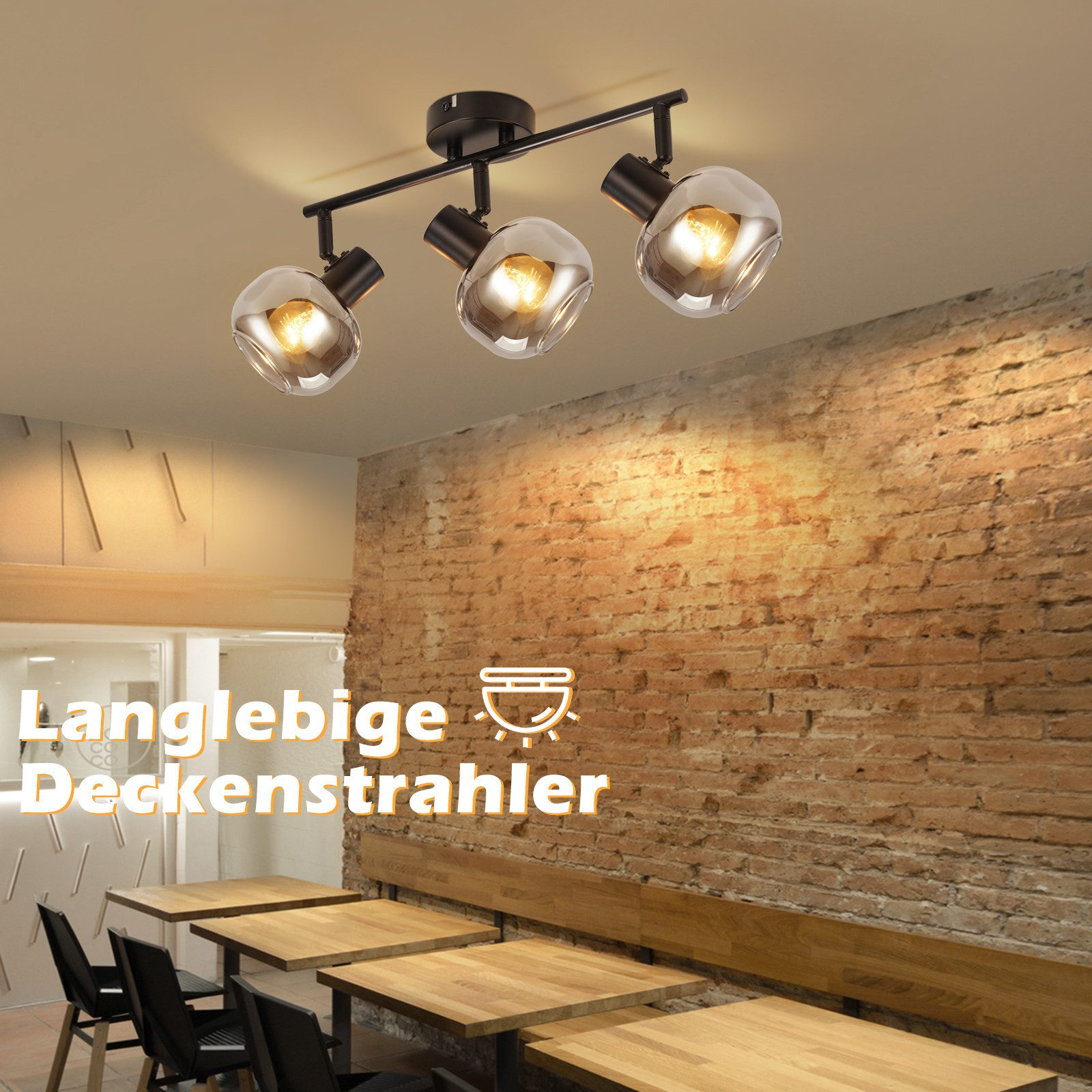 Trzy reflektory sufitowe ze szklanymi kloszami, oświetlające ceglaną ścianę i drewniane stoły poniżej.