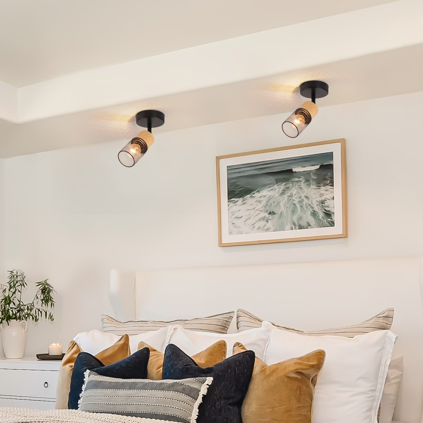 Dwa czarne reflektory zamontowane na białym suficie, obraz na ścianie.