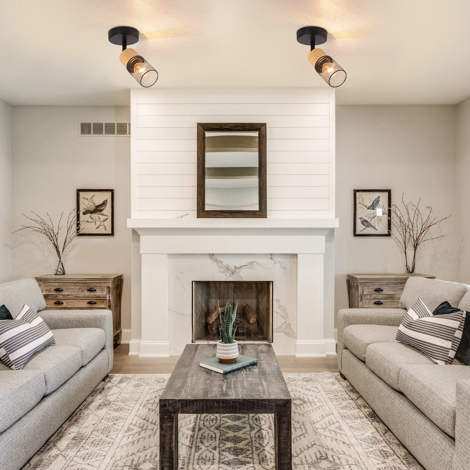 Salon z kominkiem, dwiema sofami i dwoma reflektorami sufitowymi.